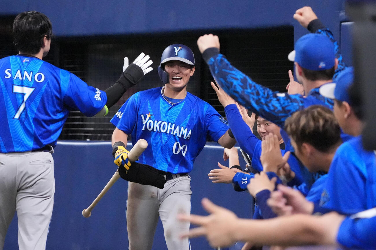 中日対DeNA 7回表DeNA2死一、三塁、林琢真（中央）は三森大貴の適時打で生還しナインとタッチを交わす（撮影・森本幸一）