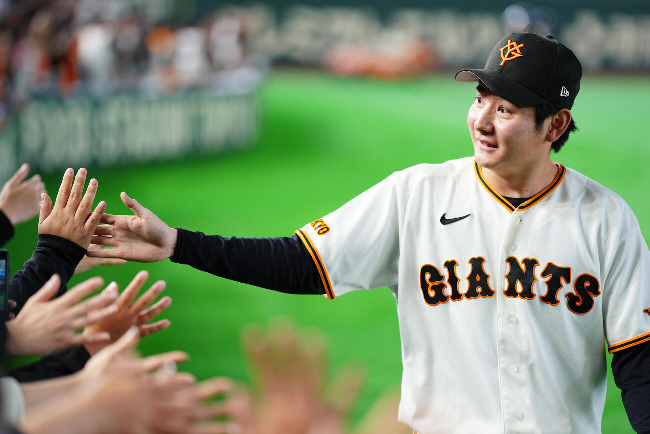 巨人対広島　試合後、ファンとタッチを交わす巨人竹丸和幸（撮影・江口和貴）