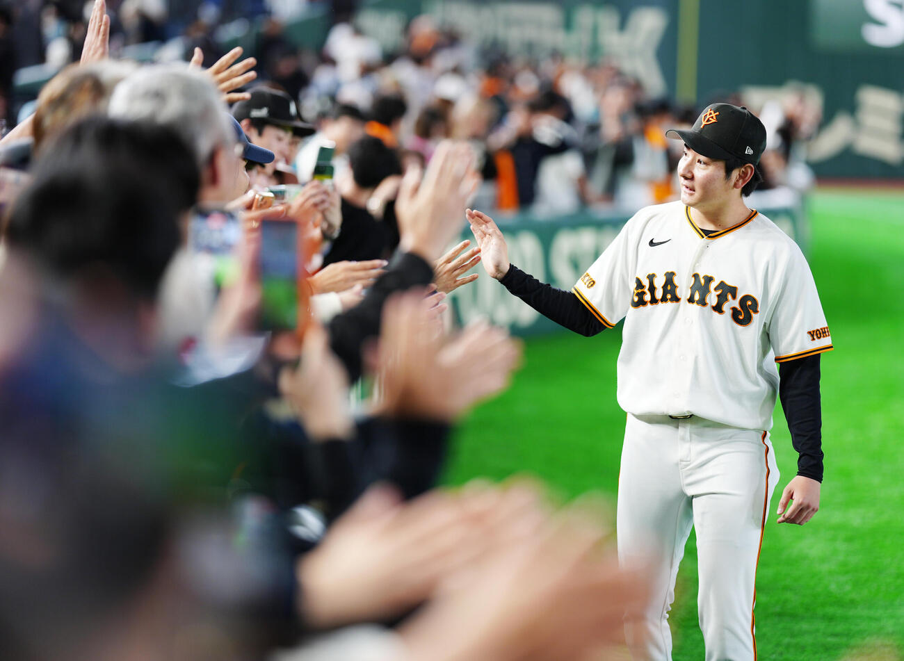 巨人対広島　試合後、ファンとタッチを交わす巨人竹丸和幸（撮影・江口和貴）