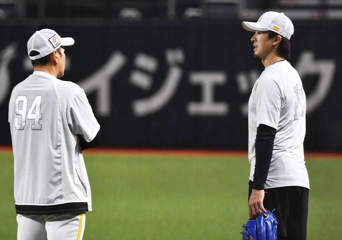 キャッチボールを終えたソフトバンク上沢直之（右）は倉野信次投手チーフコーチ兼投手ヘッドコーディネーターと話し合う（撮影・岩下翔太）