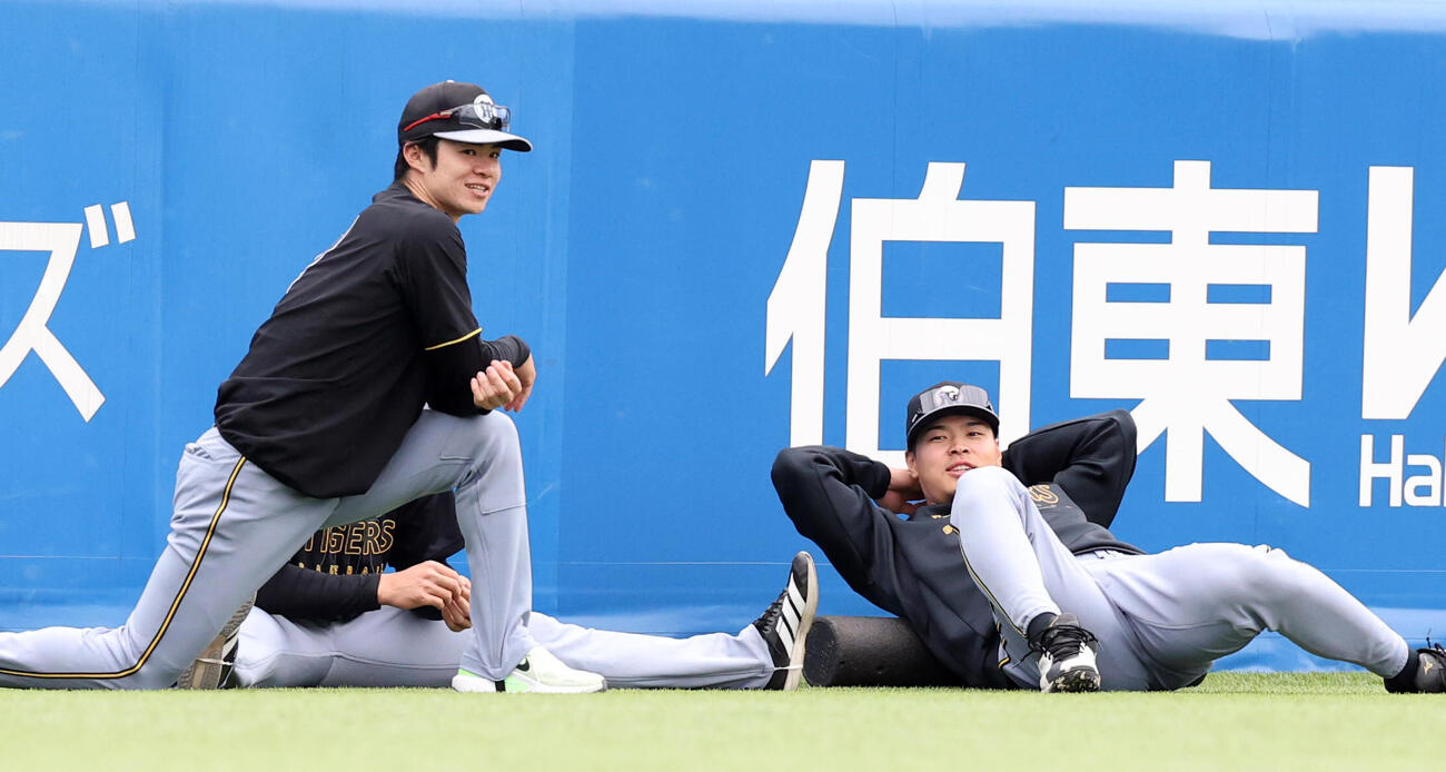 ヤクルト対阪神　笑顔でストレッチする阪神中野拓夢（左）と佐藤輝明（撮影・浅見桂子）