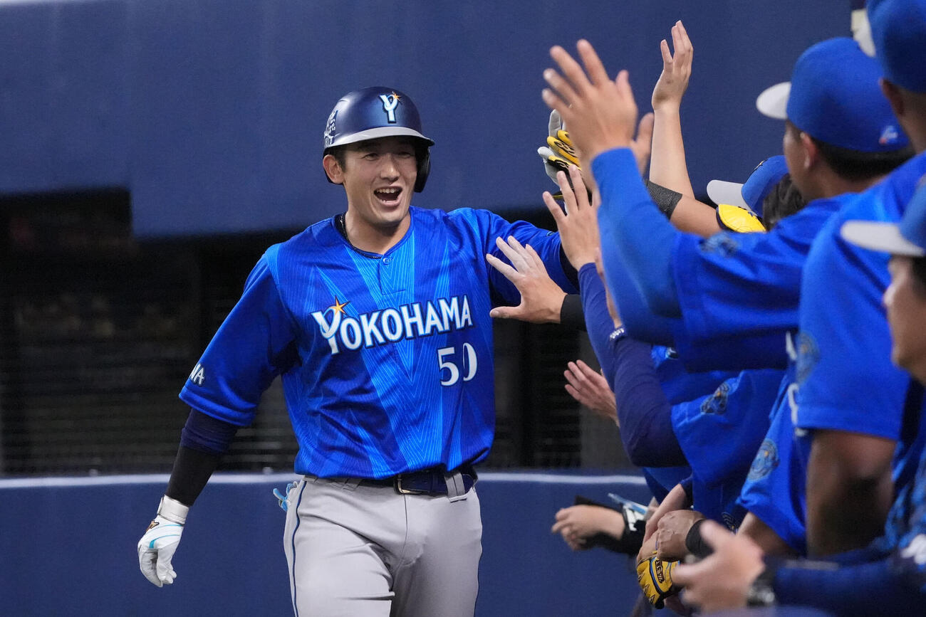 中日対DeNA 5回表DeNA無死、山本祐大（左）はソロ本塁打を放ちナインとタッチを交わす（撮影・森本幸一）