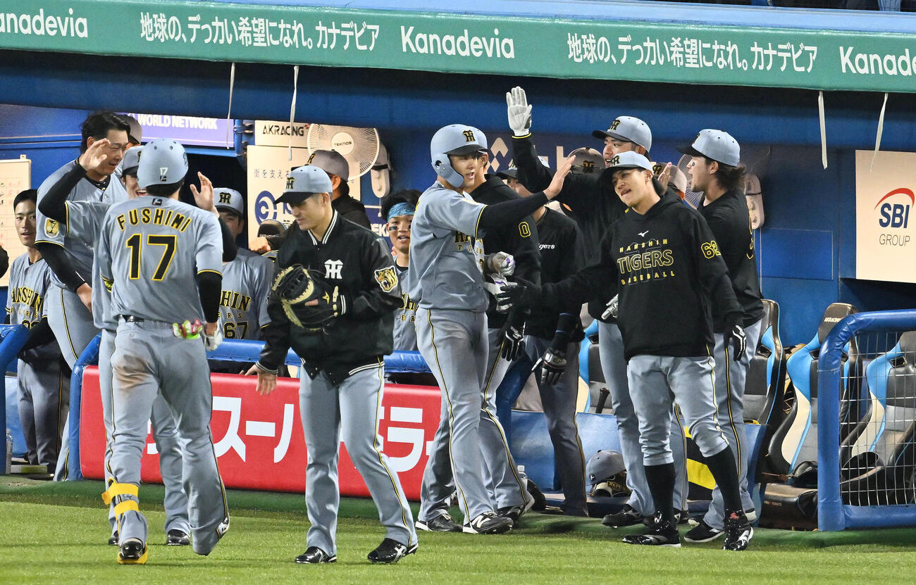 ヤクルト対阪神　3回表阪神2死二塁、伏見寅威（左手前）の適時打で生還した小幡竜平（中央）はチームメートとタッチをかわす（撮影・滝沢徹郎）