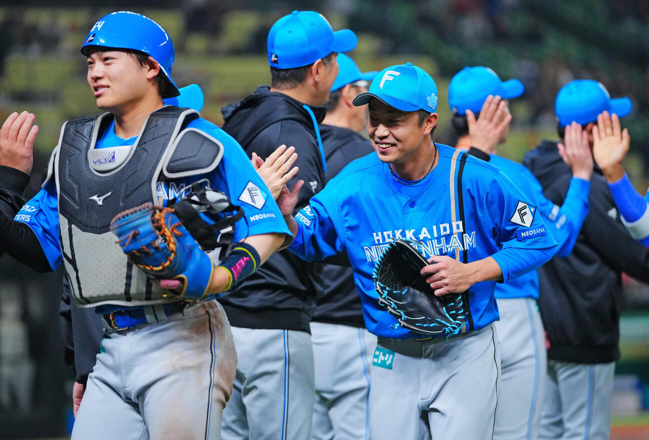 西武対日本ハム　西武に勝利しタッチを交わす日本ハム島本浩也（右）（撮影・垰建太）