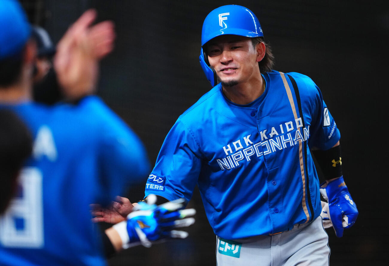 西武対日本ハム　　8回表日本ハム無死三塁、田宮裕涼の適時打で生還しナインの出迎えを受ける水野達稀（撮影・垰建太）