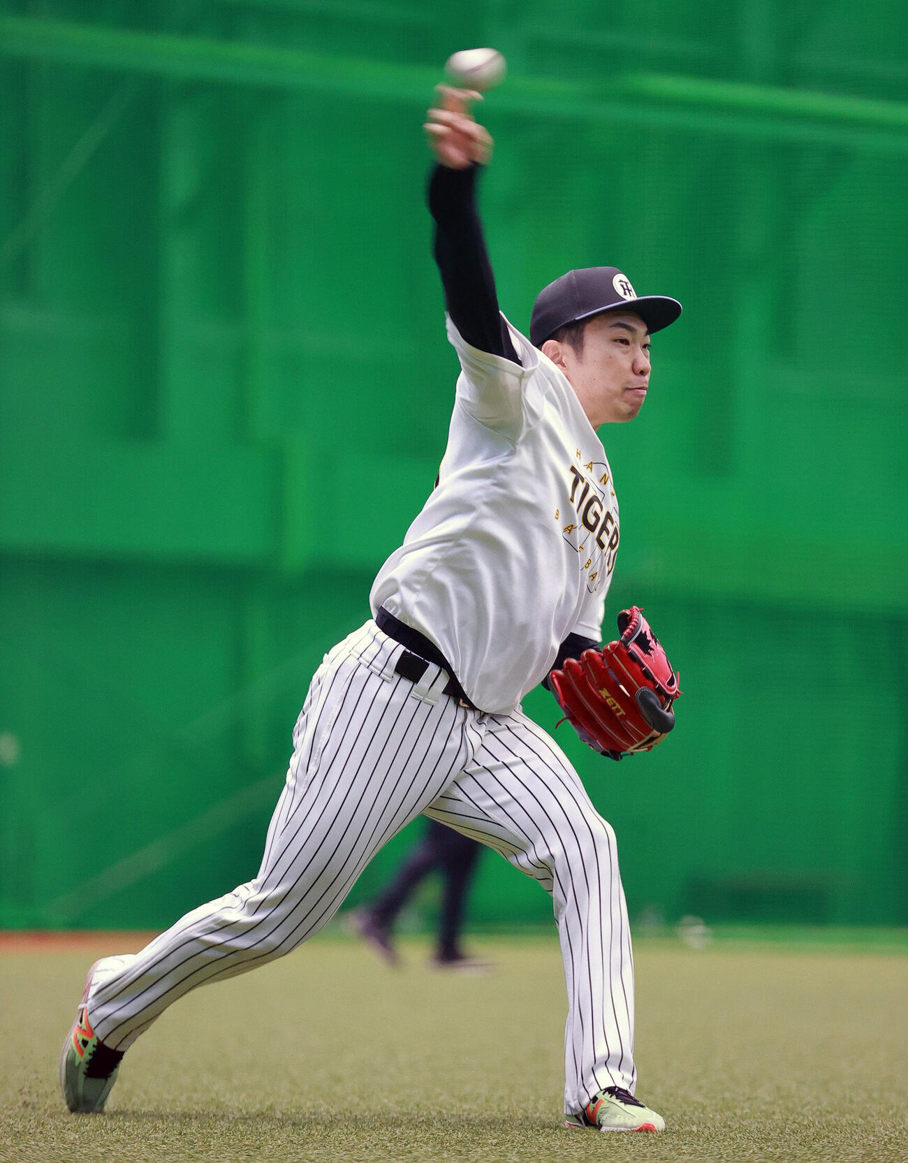 SGLスタジアムの室内でキャッチボールする阪神石井大智（撮影・上山淳一）