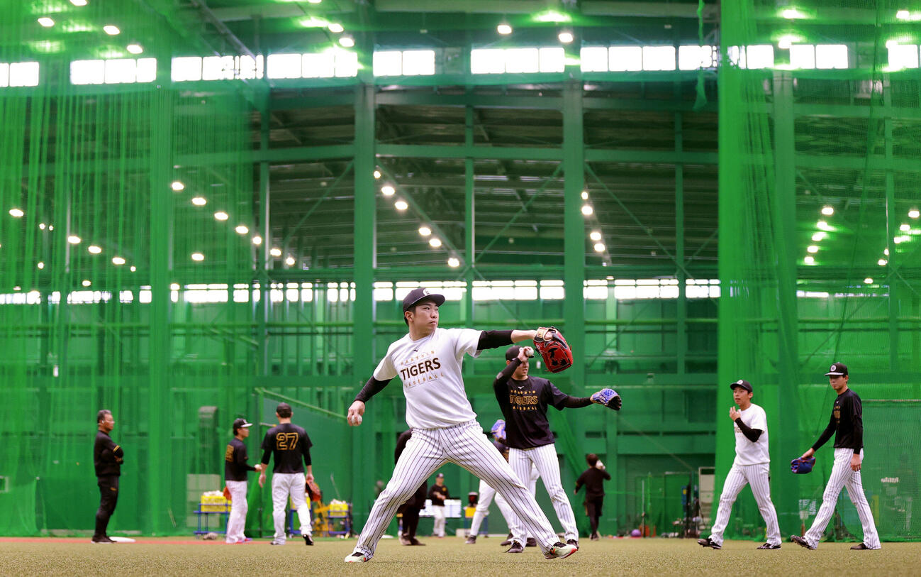 SGLスタジアムの室内でキャッチボールする阪神石井大智（撮影・上山淳一）