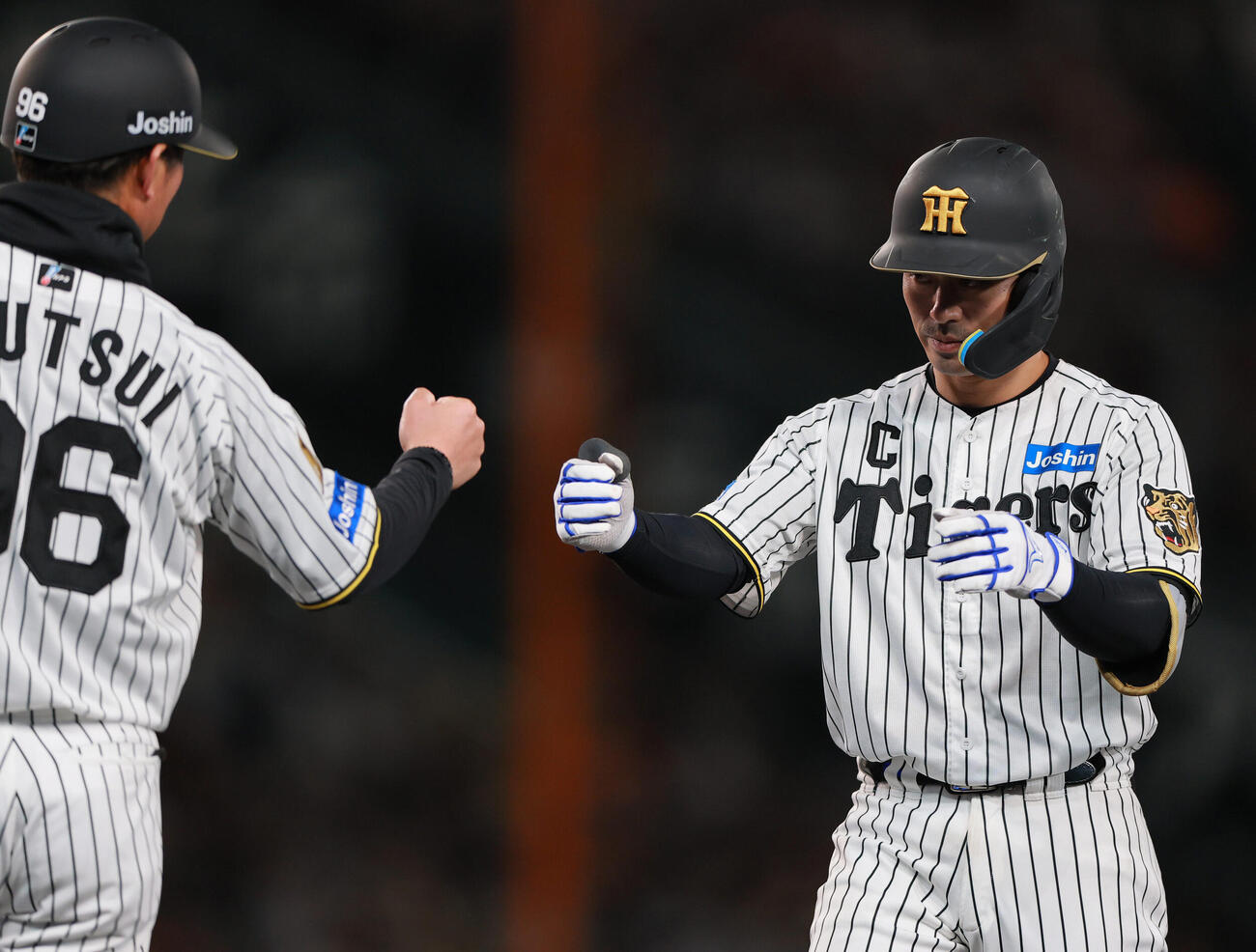 阪神対巨人　3回裏阪神2死満塁、坂本誠志郎（右）は2点適時打を放ち筒井壮外野守備兼走塁チーフコーチとタッチをかわす（撮影・上山淳一）.