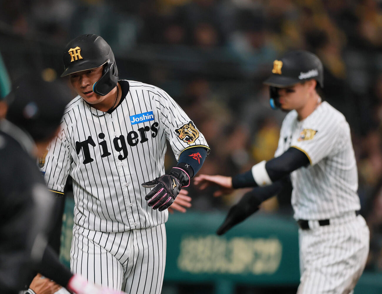 阪神対巨人　3回裏阪神2死満塁、坂本誠志郎の2点適時打で生還し、出迎えを受ける大山悠輔（左）と佐藤輝明（撮影・上山淳一）..