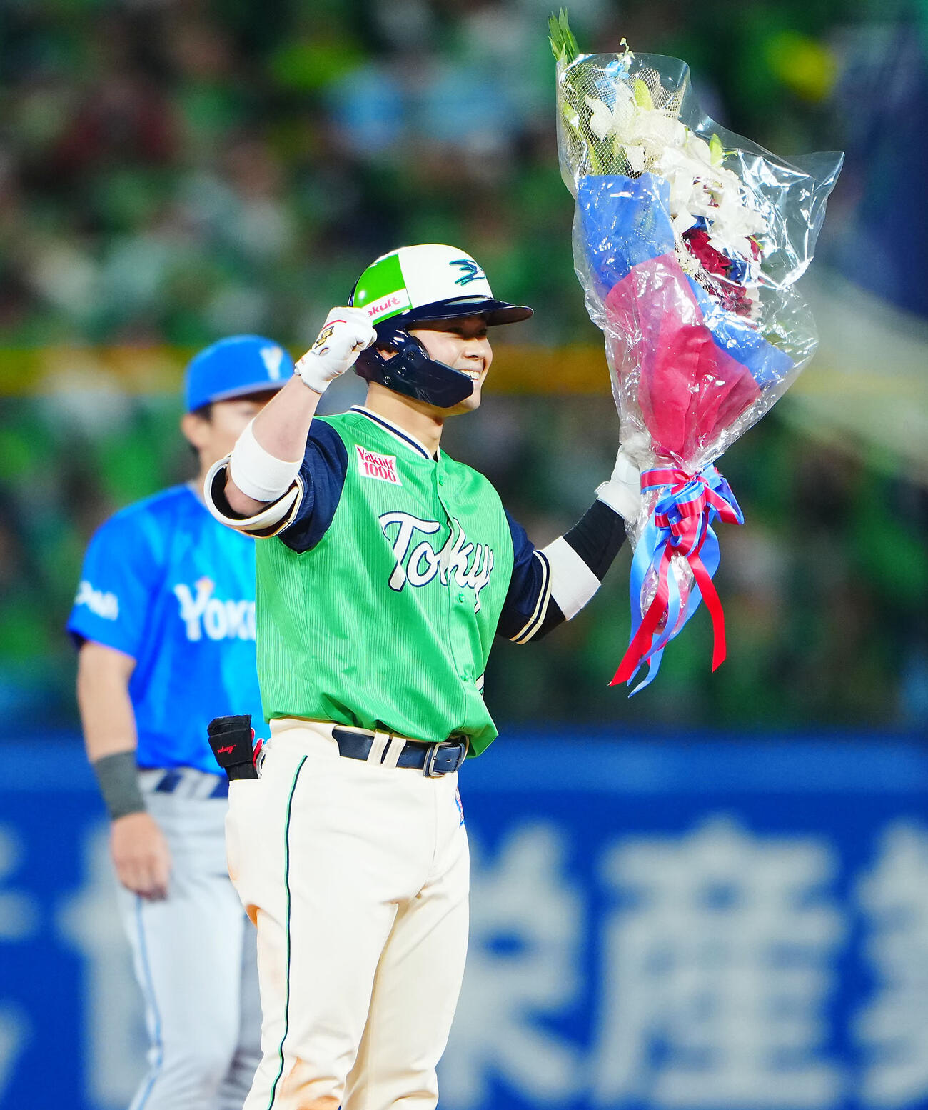 ヤクルト対DeNA 7回裏ヤクルト1死、サイクル安打達成となる二塁打を放ち塁上で花束を手に喜ぶ丸山和郁（撮影・垰建太）