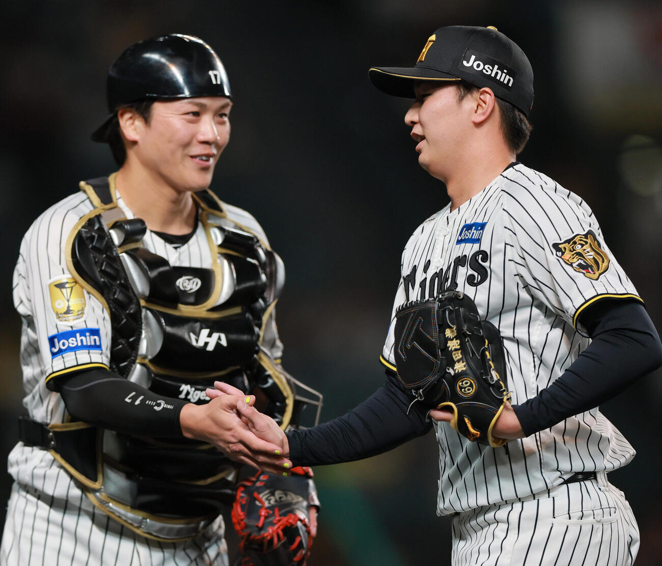阪神対巨人　9回表を無失点に抑えた阪神津田淳哉（右）は伏見寅威とタッチをかわす（撮影・上山淳一）