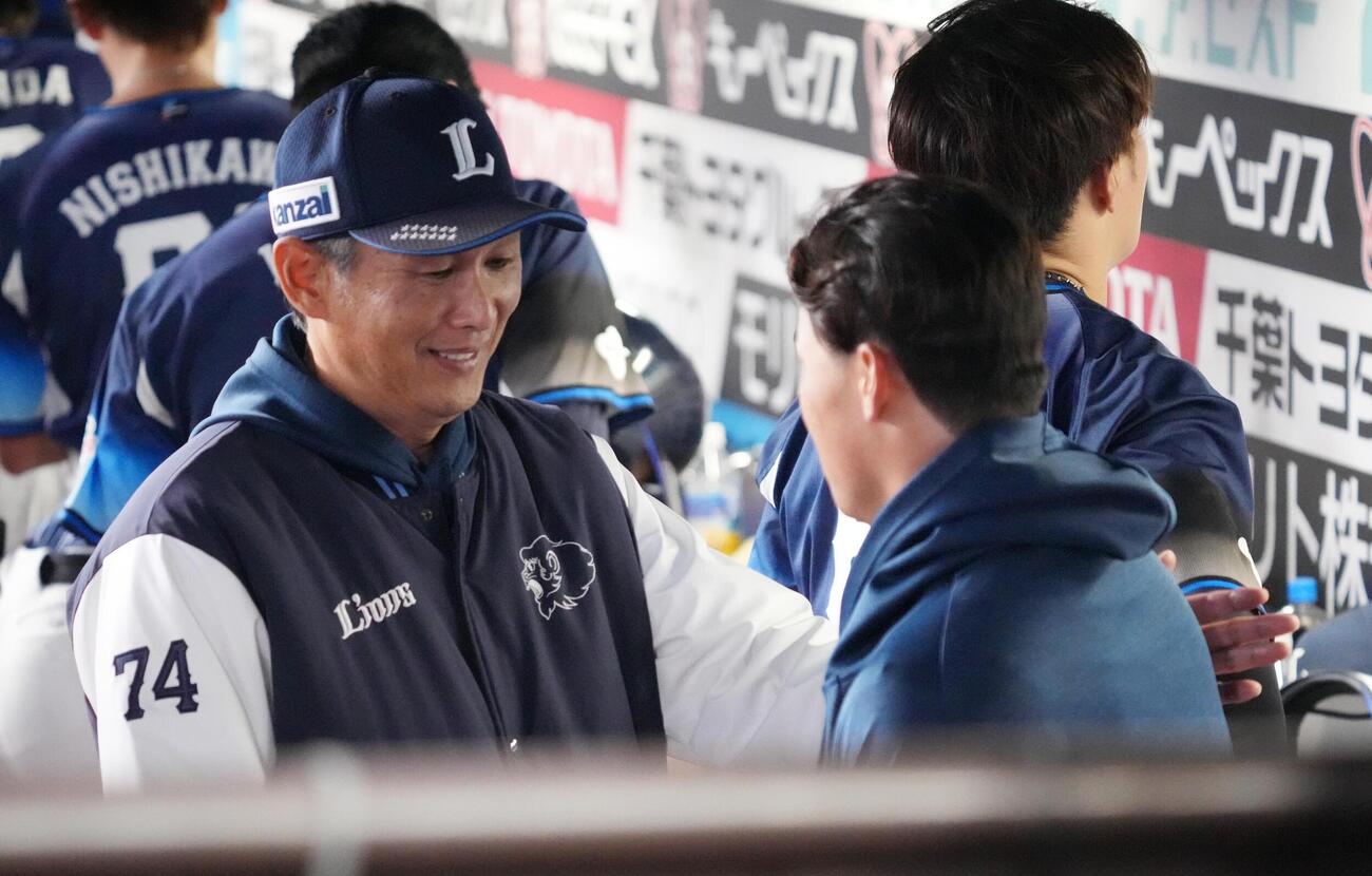 ロッテ対西武　プロ初登板初先発で7回2安打無失点と好投した西武佐藤爽（右）は西口文也監督の祝福を受ける（撮影・小沢裕）