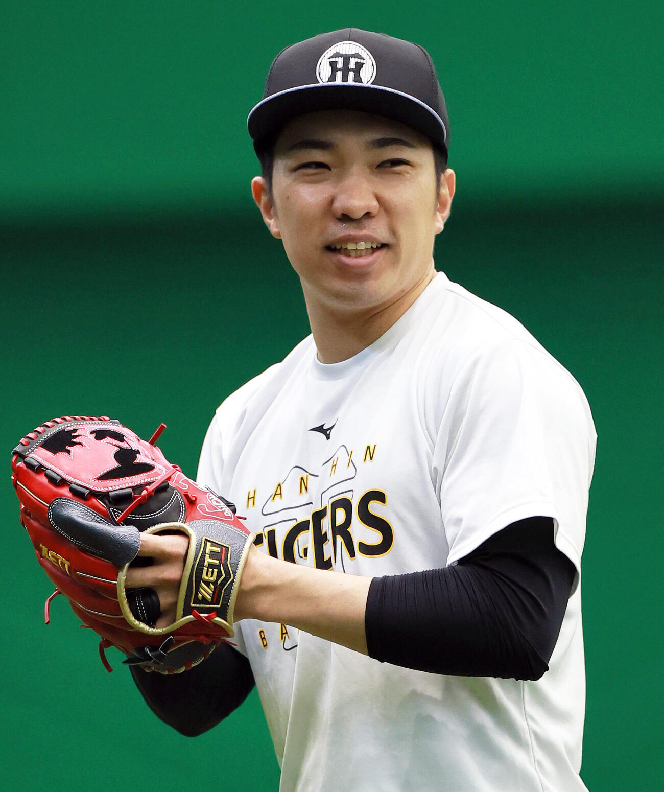 SGLスタジアムの室内でキャッチボールする阪神石井大智（撮影・上山淳一）