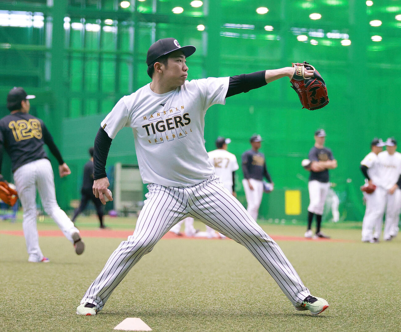SGLスタジアムの室内でキャッチボールする阪神石井大智（撮影・上山淳一）