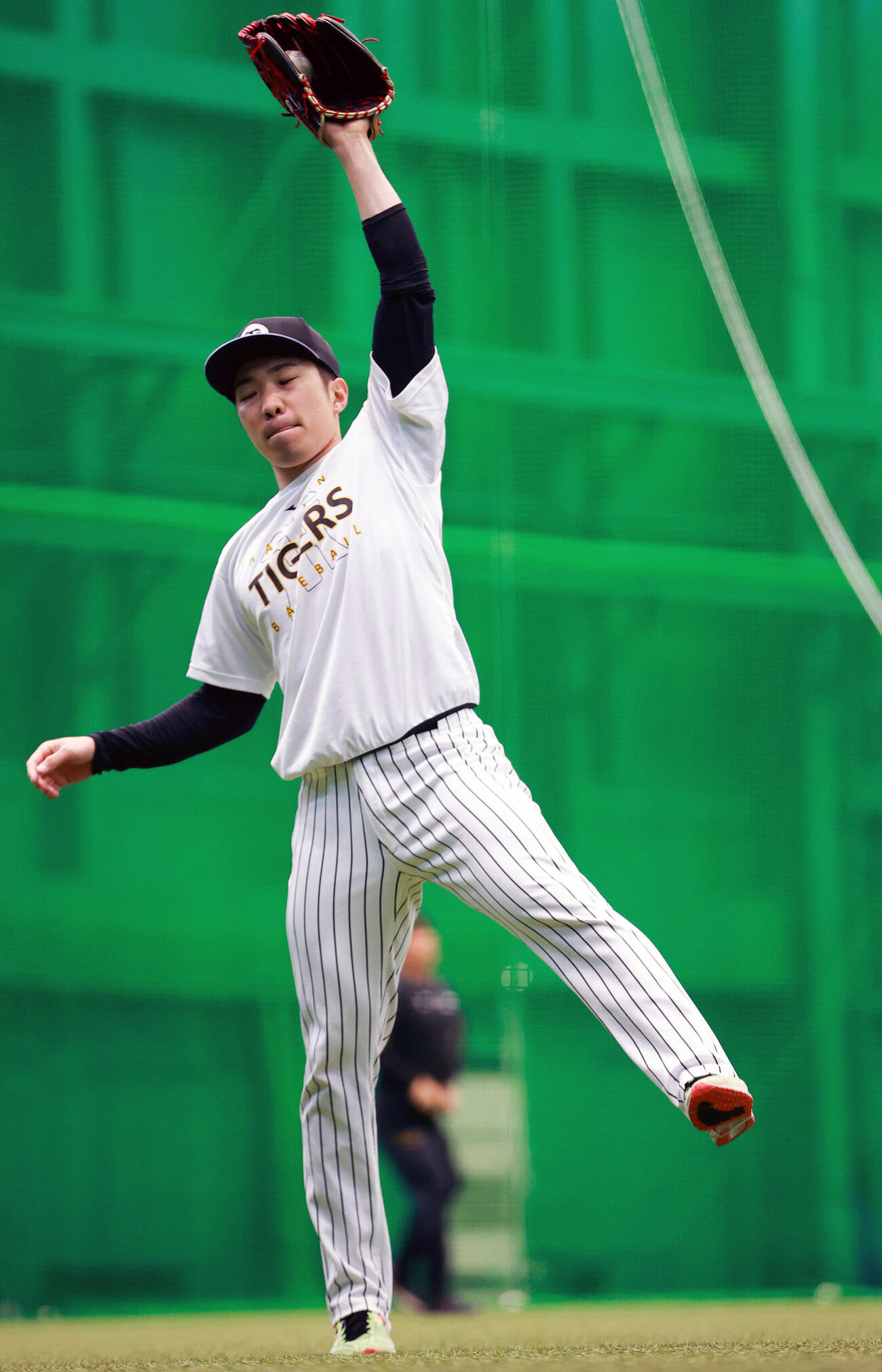 SGLスタジアムの室内でキャッチボールする阪神石井大智（撮影・上山淳一）