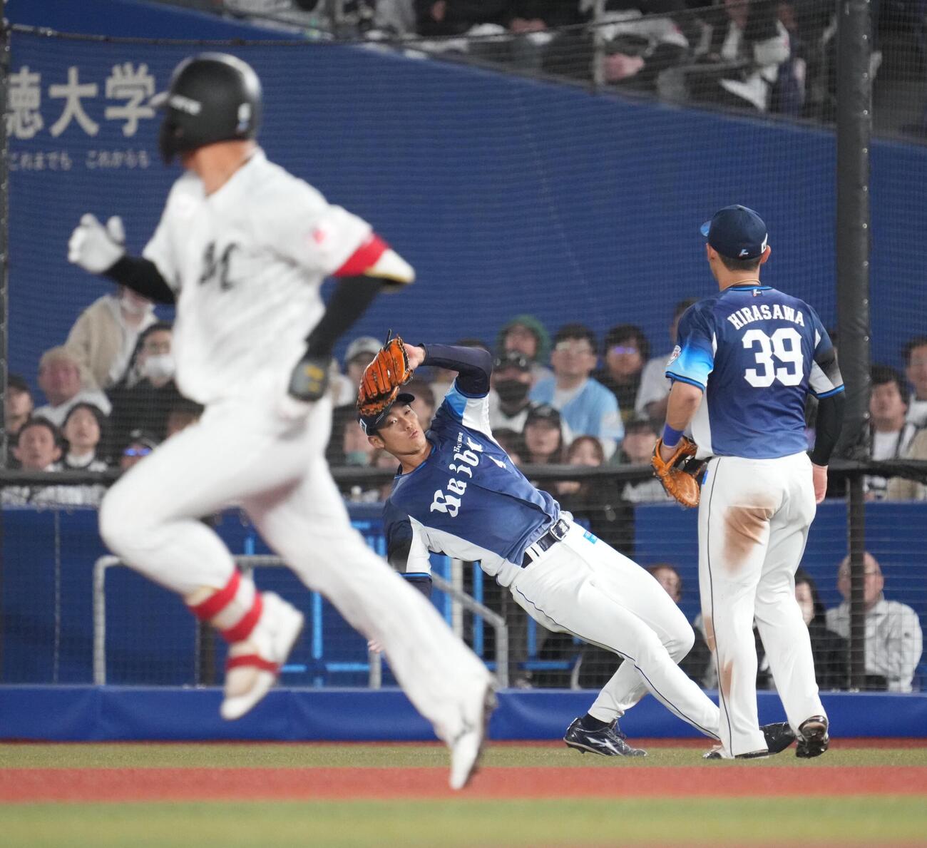 ロッテ対西武　6回裏ロッテ1死、西武石井一成二塁手は西川史礁（左）の飛球を風の影響を受けながらも捕球する（撮影・小沢裕）