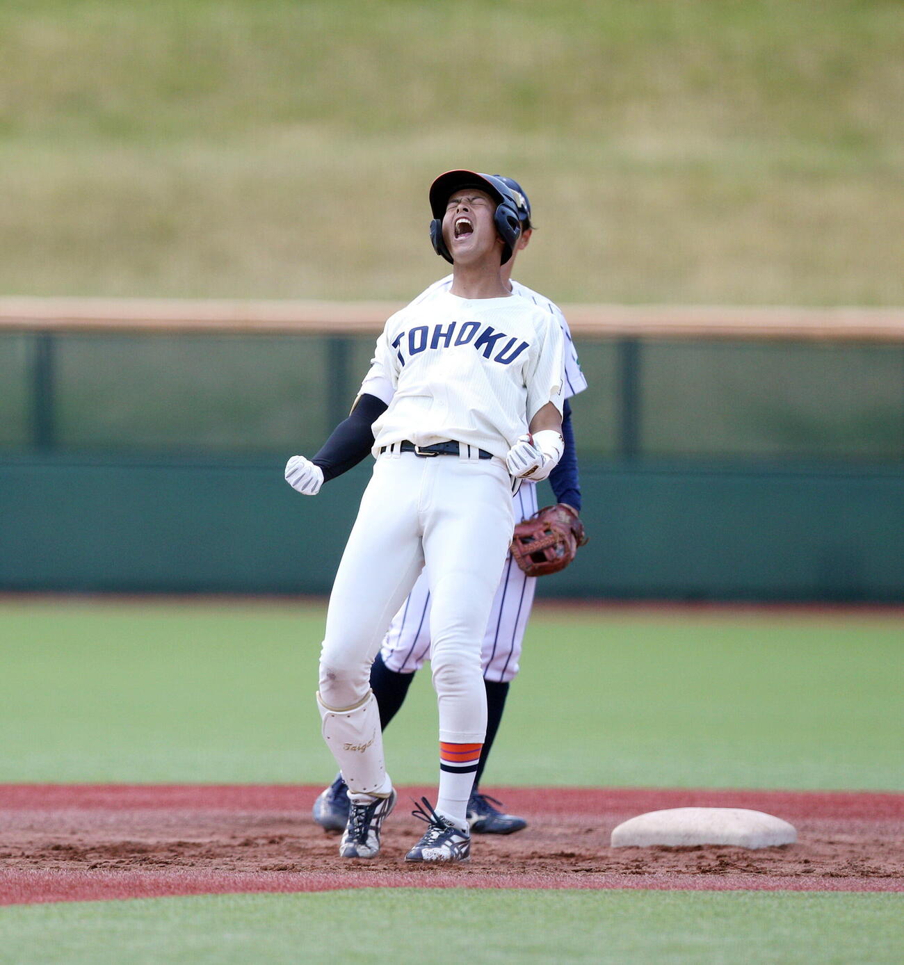 仙台6大学野球春季リーグ　東北福祉大対仙台大　5回表東北福祉大2死一、三塁、勝ち越し中前打を放ち、塁上で雄たけびをあげる東北福祉大・辻村