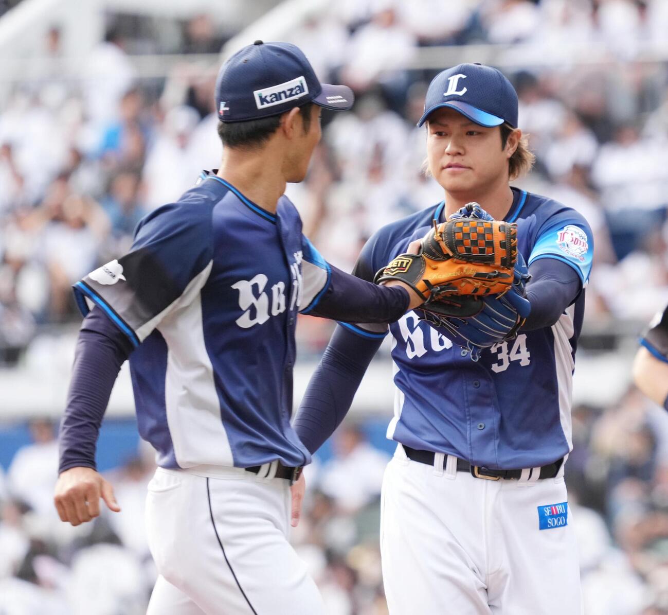 ロッテ対西武　7回途中から2番手で登板した甲斐野央（右）はこの回を無失点でしのぎ石井一成とグラブタッチ（撮影・小沢裕）