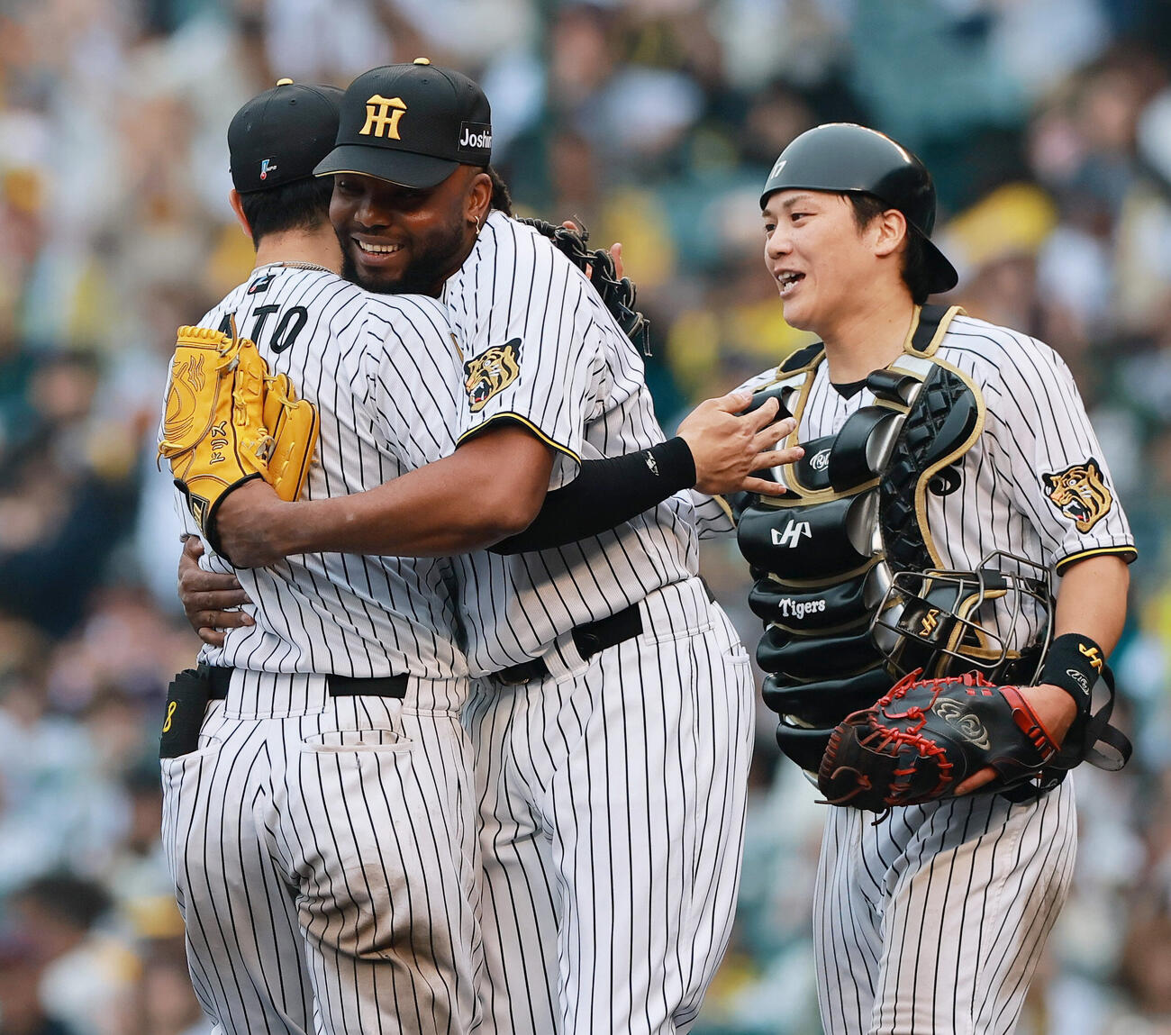 阪神対巨人　巨人に勝利し、試合を締めたラファエル・ドリス（中央）は通算100セーブを達成し佐藤輝明とハグする。右は伏見寅威（撮影・上山淳一）