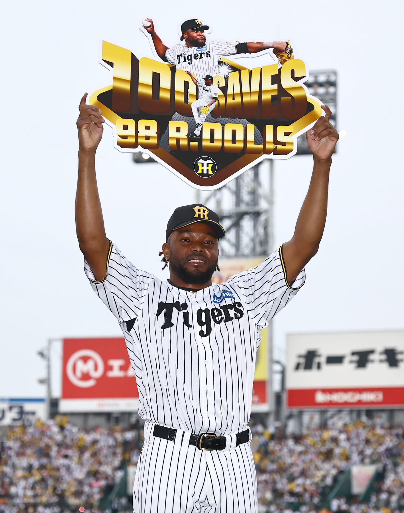 阪神対巨人　100セーブを達成したラファエル・ドリスは記念ボードを高々と上げる（撮影・上田博志）