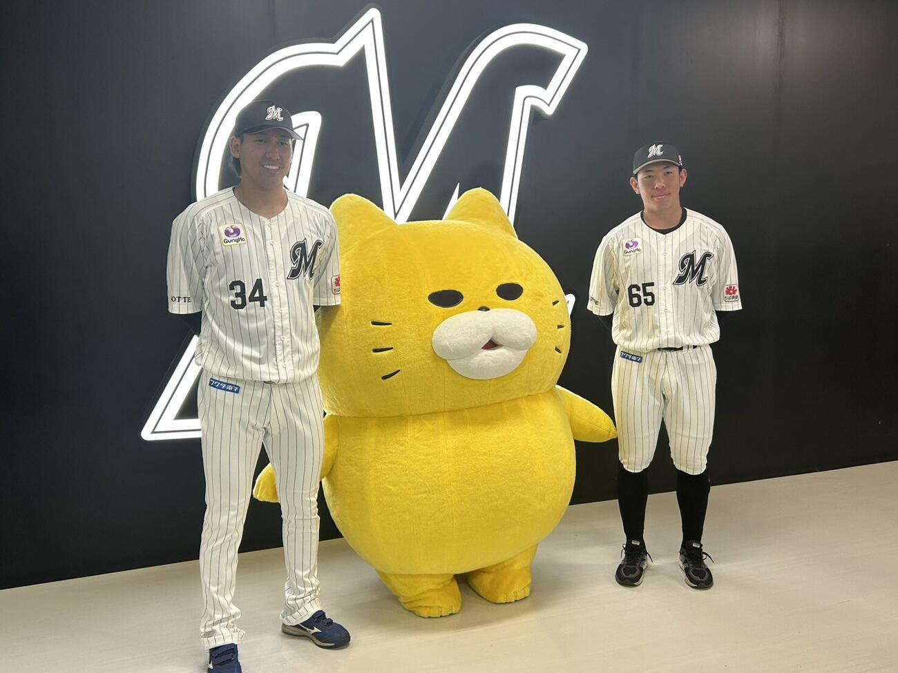 「ノラネコぐんだん」と写真撮影をする高野脩汰（左）と寺地隆成