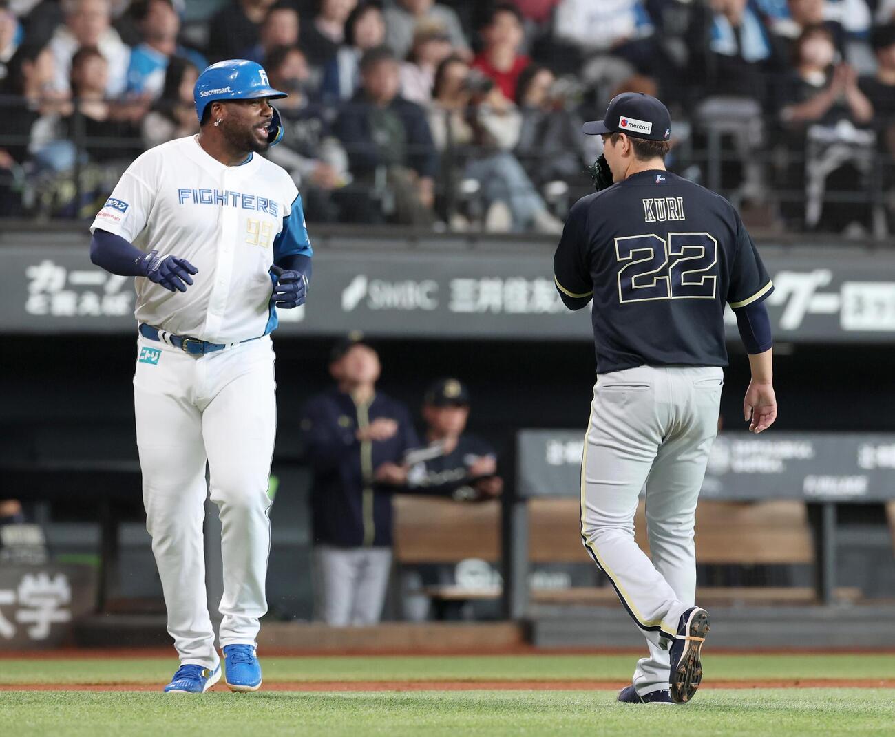日本ハム対オリックス　3回裏終了後、すれ違いざまにレイエス（左）と話す九里亜蓮（撮影・黒川智章）