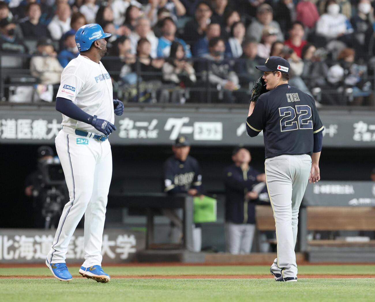 日本ハム対オリックス　3回裏終了後、すれ違いざまにレイエス（左）と話す九里亜蓮（撮影・黒川智章）