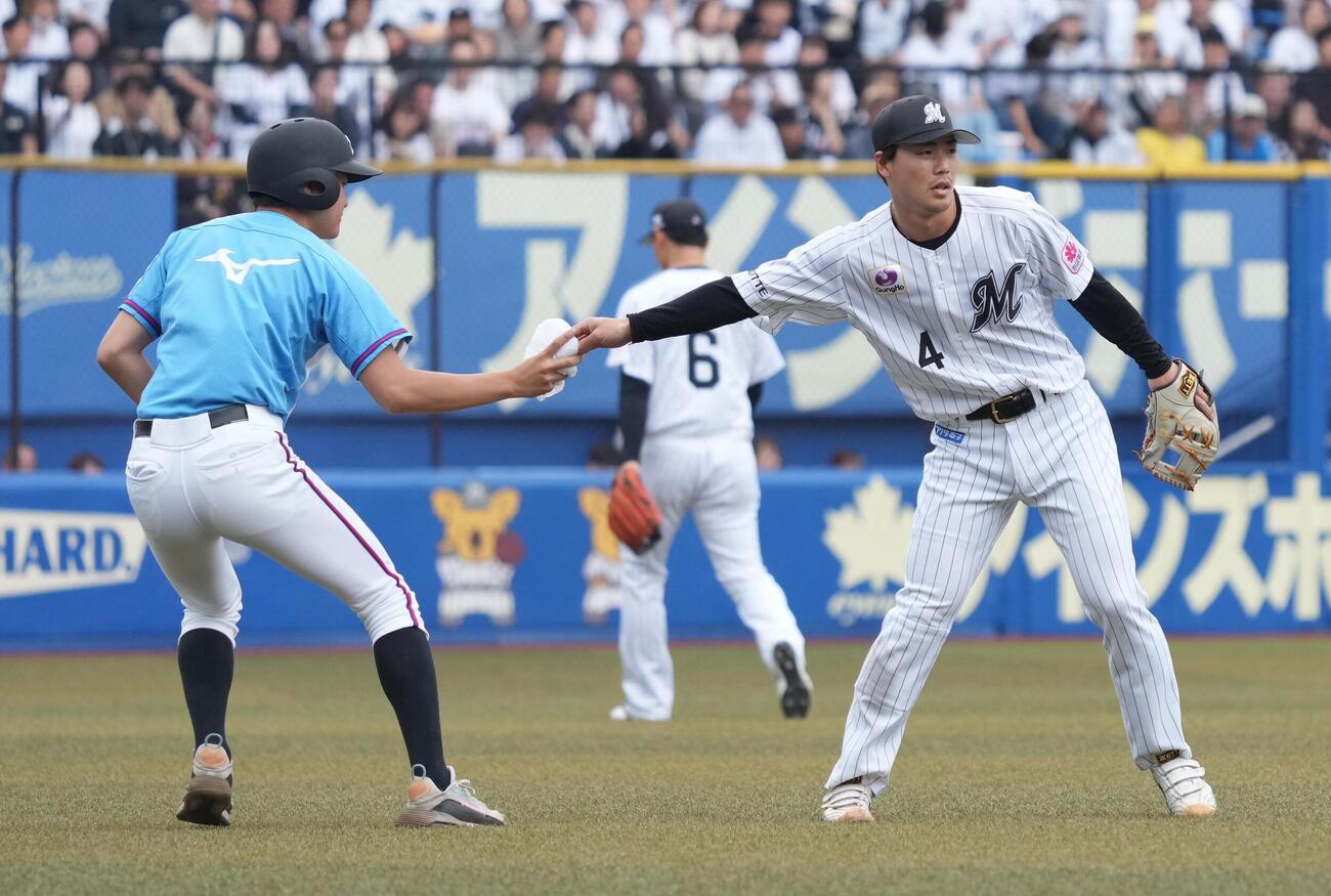 ロッテ対西武　グラウンドに舞い落ちてきたビニール袋を回収しボールボーイに渡すロッテ友杉篤輝（撮影・小沢裕）