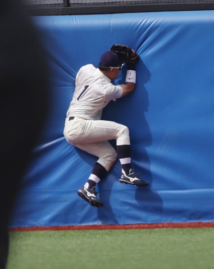 東京6大学野球　明大対立大　6回裏立大無死、長島颯の打球にジャンプしフェンスに激突する明大・榊原七斗（撮影・柴田隆二）