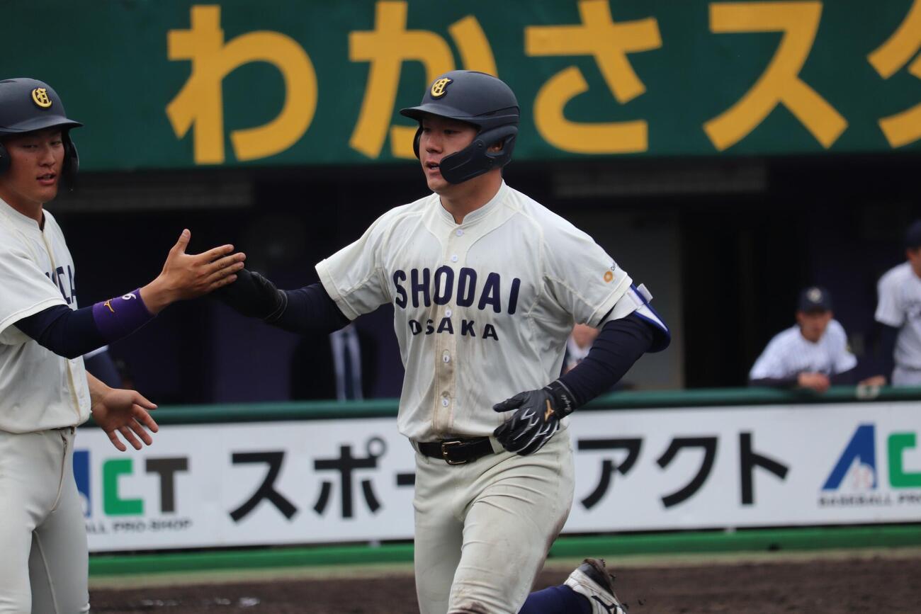 大院大対大商大　3回、第3打席で本塁打を放ち仲間とタッチを交わす大商大・春山陽登