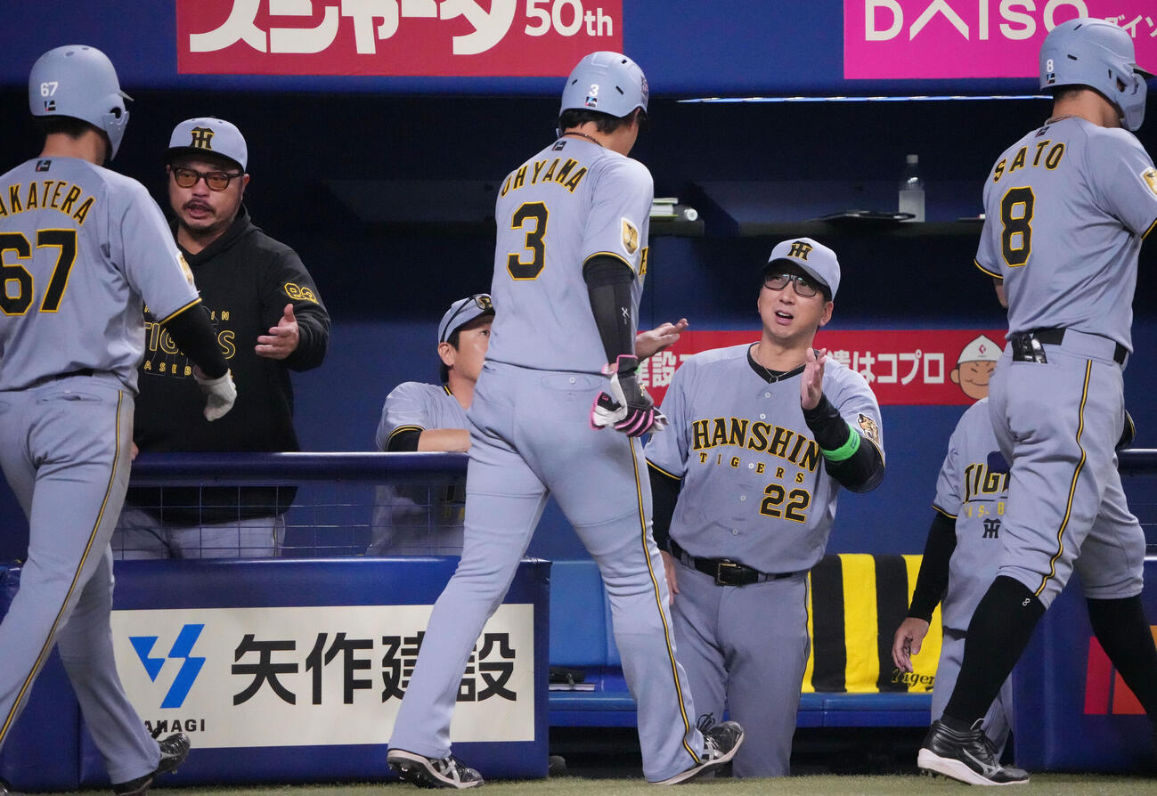 中日対阪神　1回表阪神2死満塁、藤川球児監督（右から2人目）は前川右京の3点適時二塁打で生還した佐藤輝明らを迎える（撮影・森本幸一）