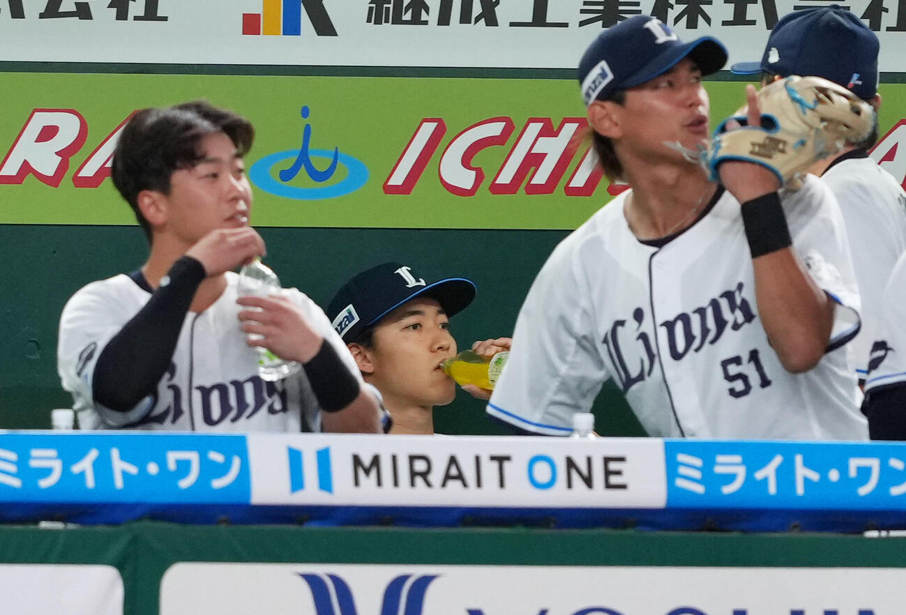 西武対ソフトバンク　2回を終え、ベンチでドリンクを口にする西武菅井信也（中央）（撮影・足立雅史）