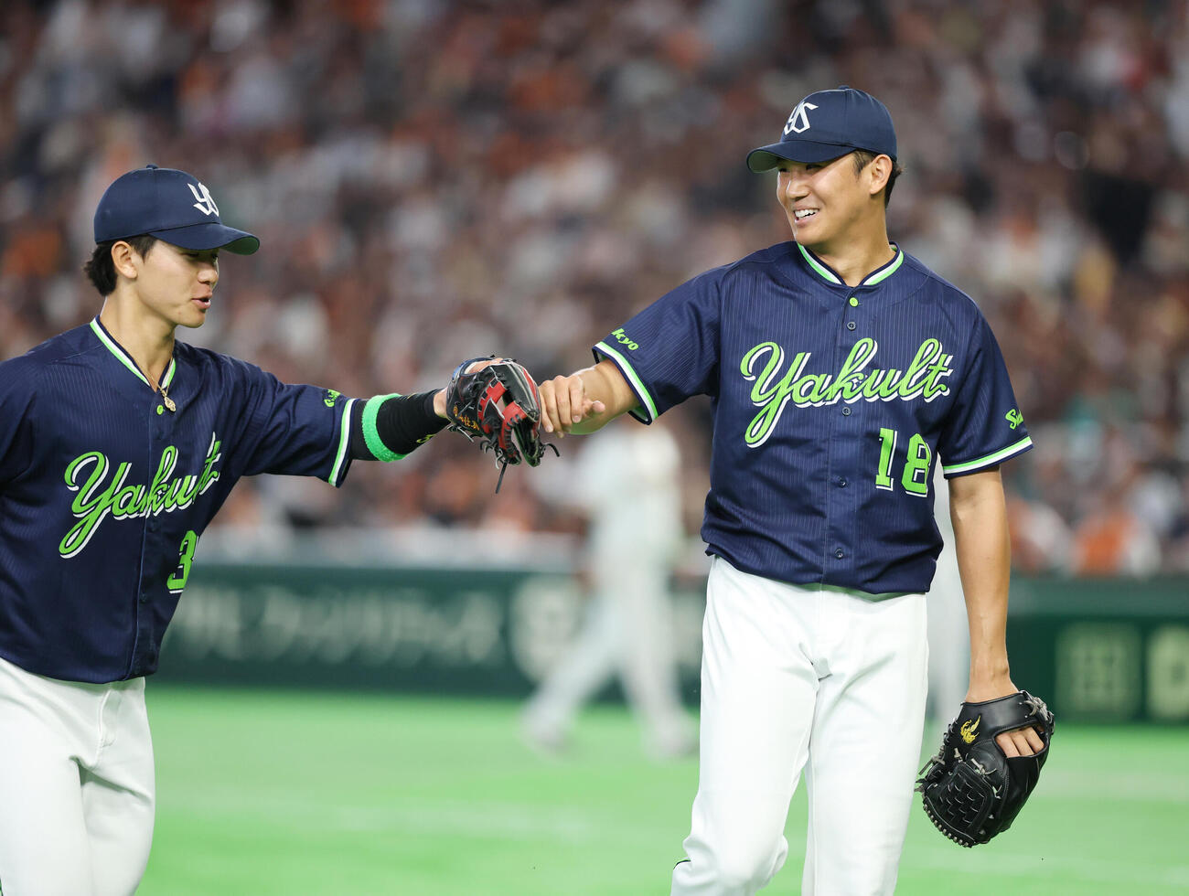 巨人対ヤクルト　3回裏を無失点に抑え内山壮真（左）とタッチ交わす奥川恭伸（撮影・増田悦実）