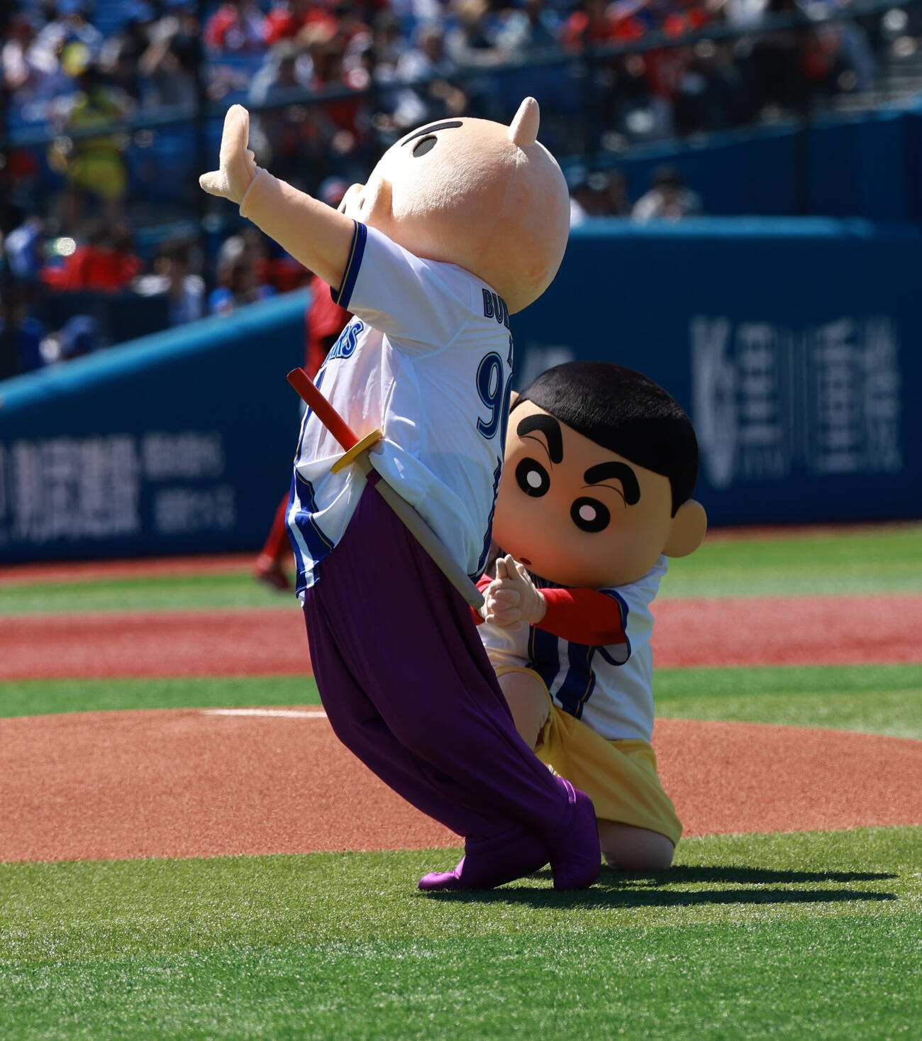 DeNA対広島　試合前、セレモニアルピッチのため登場したクレヨンしんちゃん（右）はぶりぶりざえもんにカンチョウ（撮影・水谷安孝）