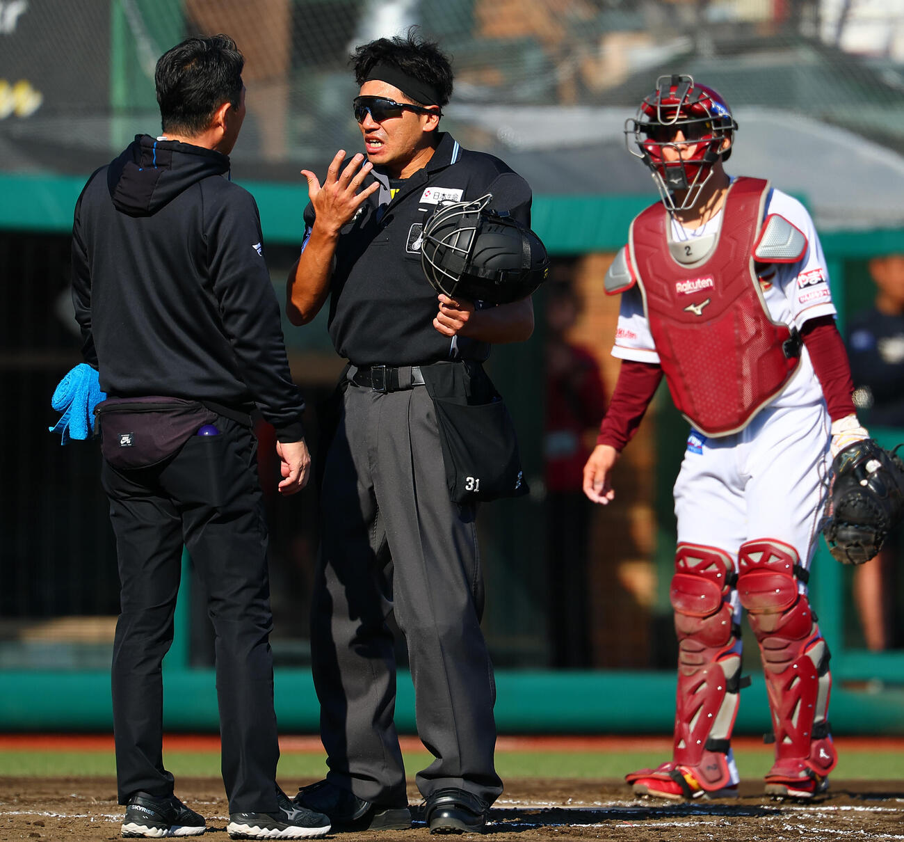 楽天対日本ハム　7回表日本ハム1死、安打を放った郡司裕也の折れたバットが直撃も、心配する日本ハムのトレーナーに無事を説明する長川真也球審（撮影・野上伸悟）