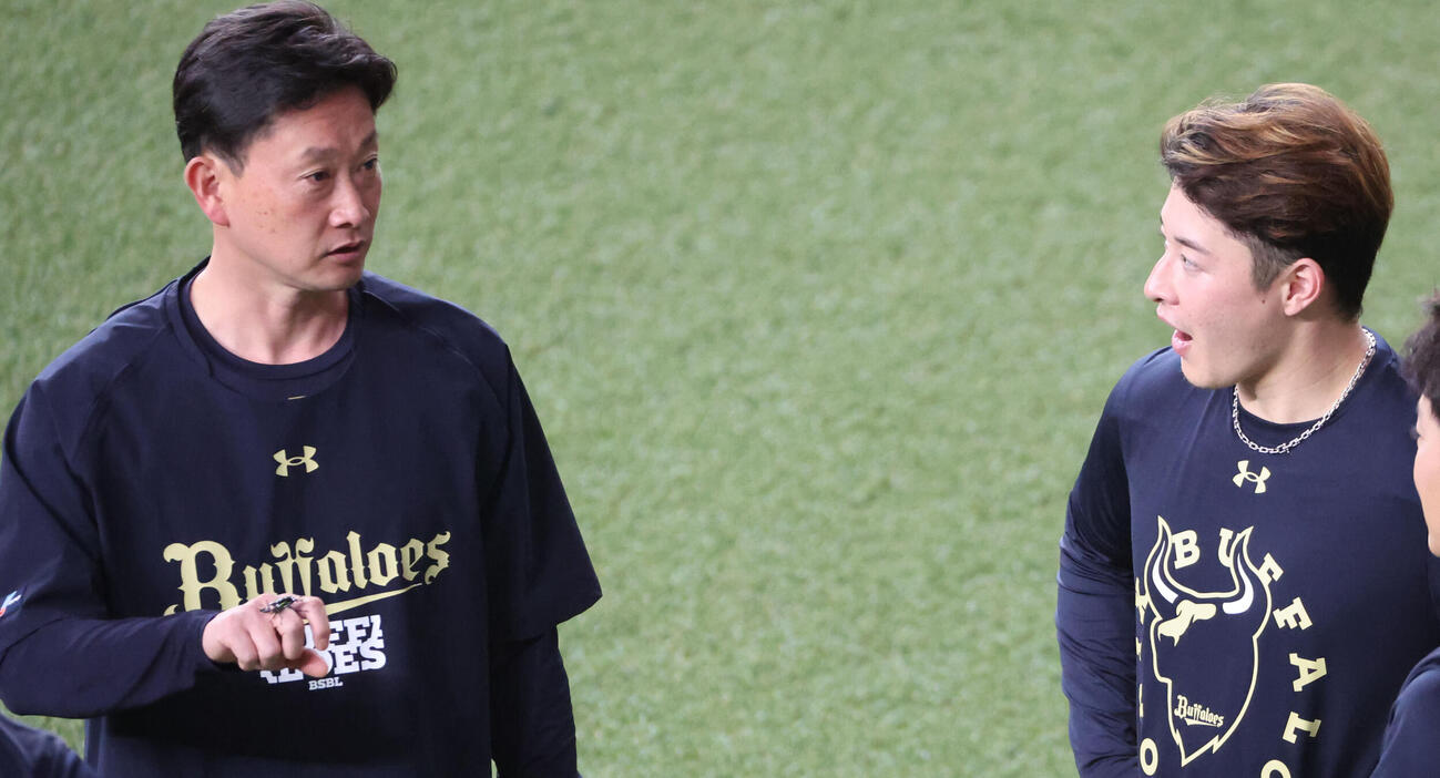 オリックス対ロッテ　試合前の練習でオリックス岸田護監督は外野でニジイロクワガタを採集、吉田輝星に見せる（撮影・西尾就之）