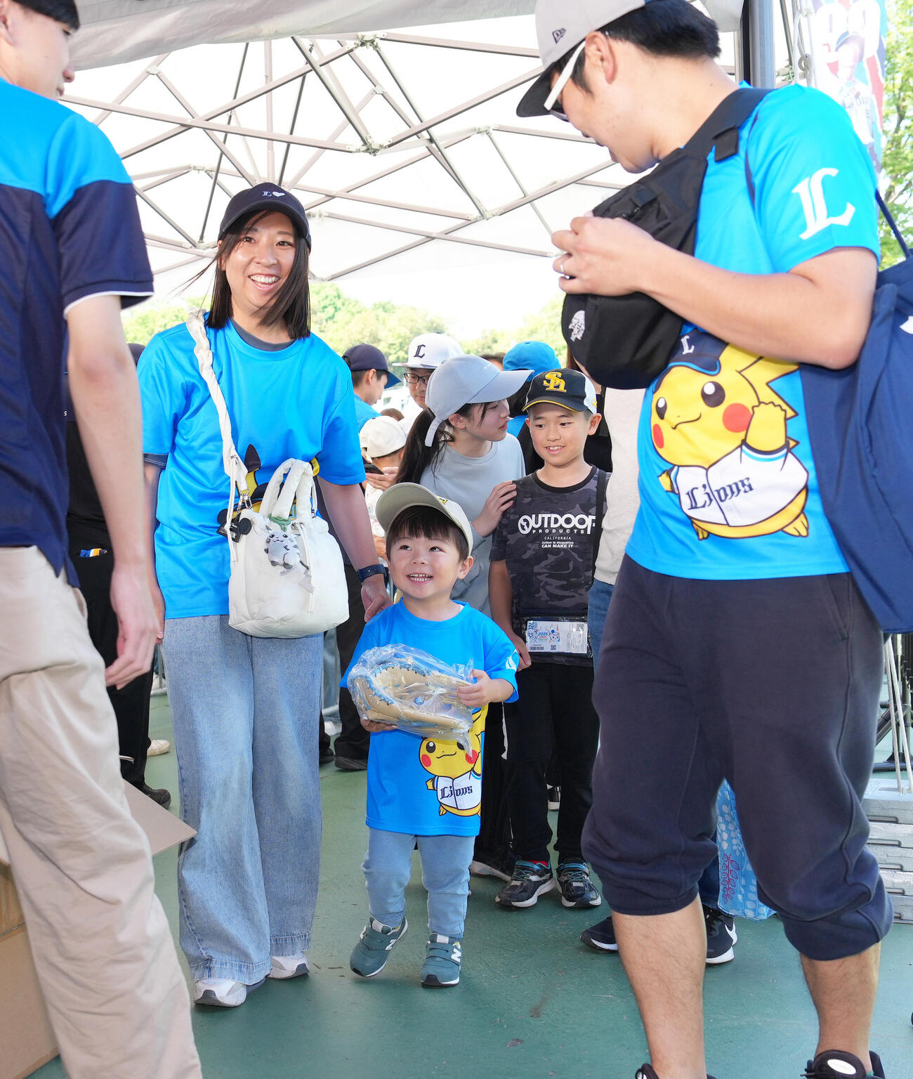 西武対ソフトバンク　小学生以下の来場者に向けた西武西川愛也監修のキッズグローブを受け取り笑顔を見せる子ども（撮影・足立雅史）