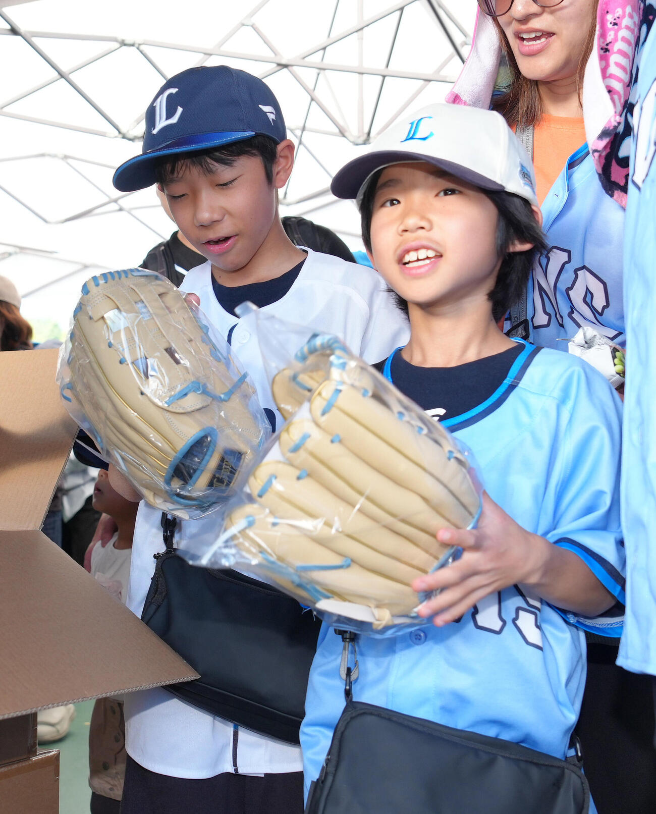 西武対ソフトバンク　小学生以下の来場者に向けた西武西川愛也監修のキッズグローブを受け取る子どもたち（撮影・足立雅史）