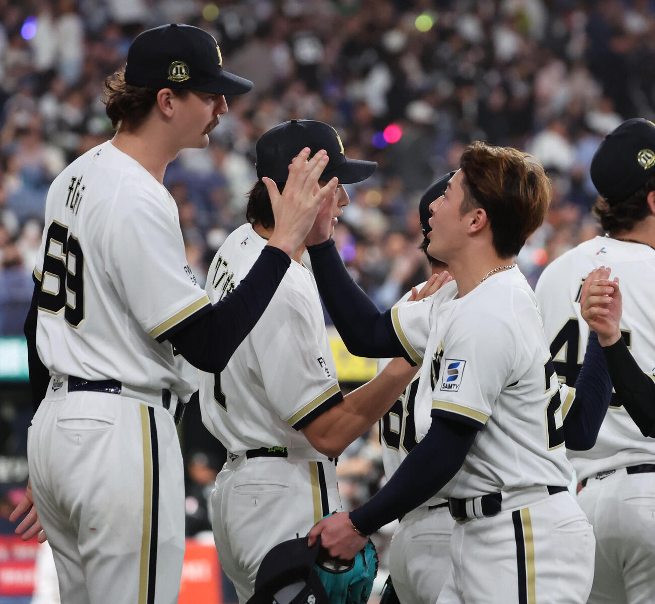 オリックス対ロッテ　初勝利を挙げたオリックスのショーン・ジェリーは、吉田輝星とタッチをかわす（撮影・西尾就之）