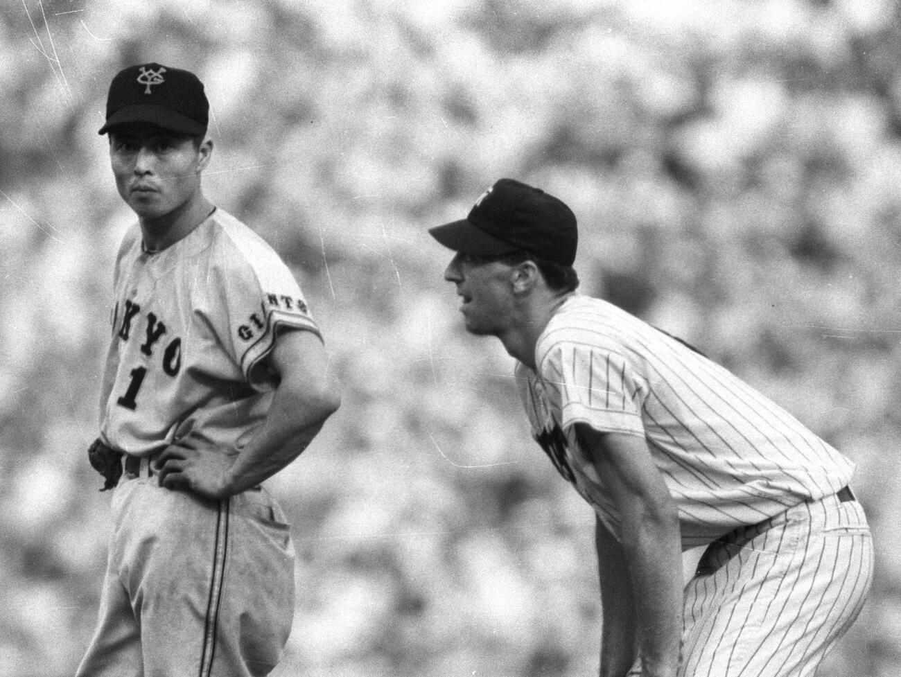 阪神対巨人　ジーン・バッキー投手（右）の、塁上での表情。王貞治一塁手（左）（1964年撮影）