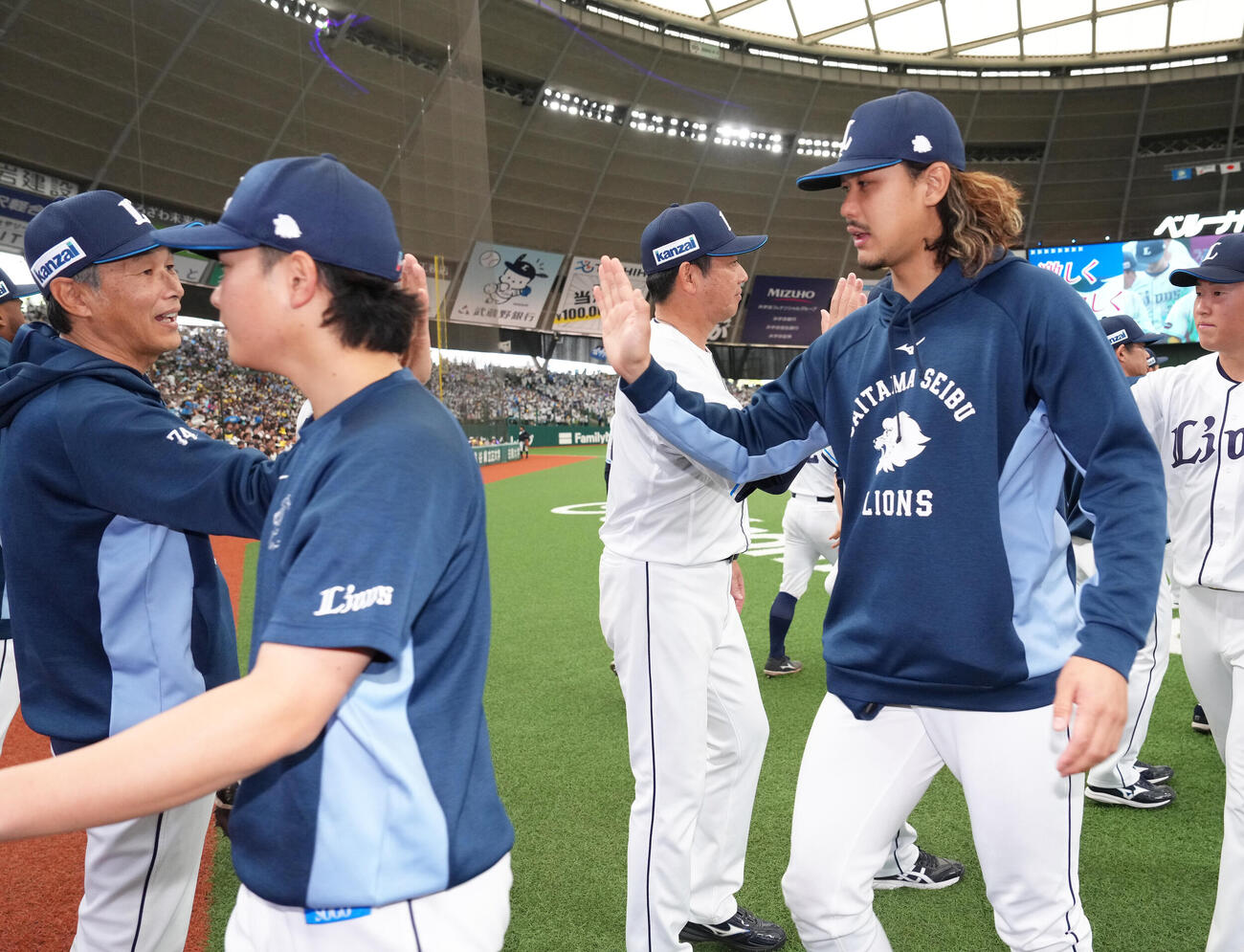 西武対ソフトバンク　ソフトバンクに快勝し、タッチを交わす西武西口文也監督（左）、高橋光成（右）ら（撮影・足立雅史）