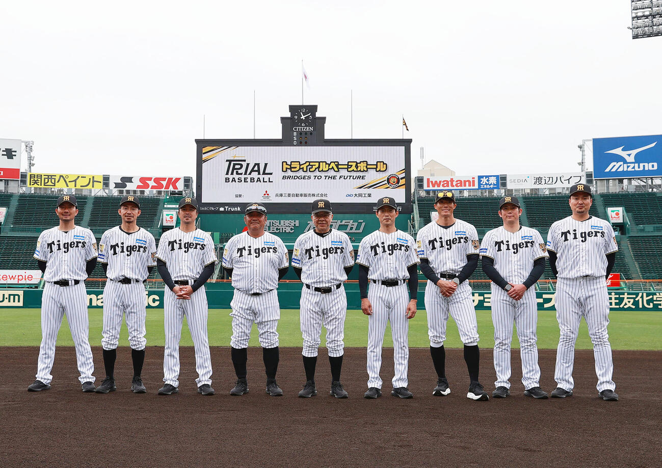 甲子園トライアルベースボールで記念撮影する、左から阪神OB狩野恵輔氏、阪鳥谷敬氏、葛城育郎氏、亀山努氏、掛布雅之OB会長、桧山進次郎氏、糸井嘉男SA、岩田稔CA、秋山拓巳BA（撮影・上山淳一）