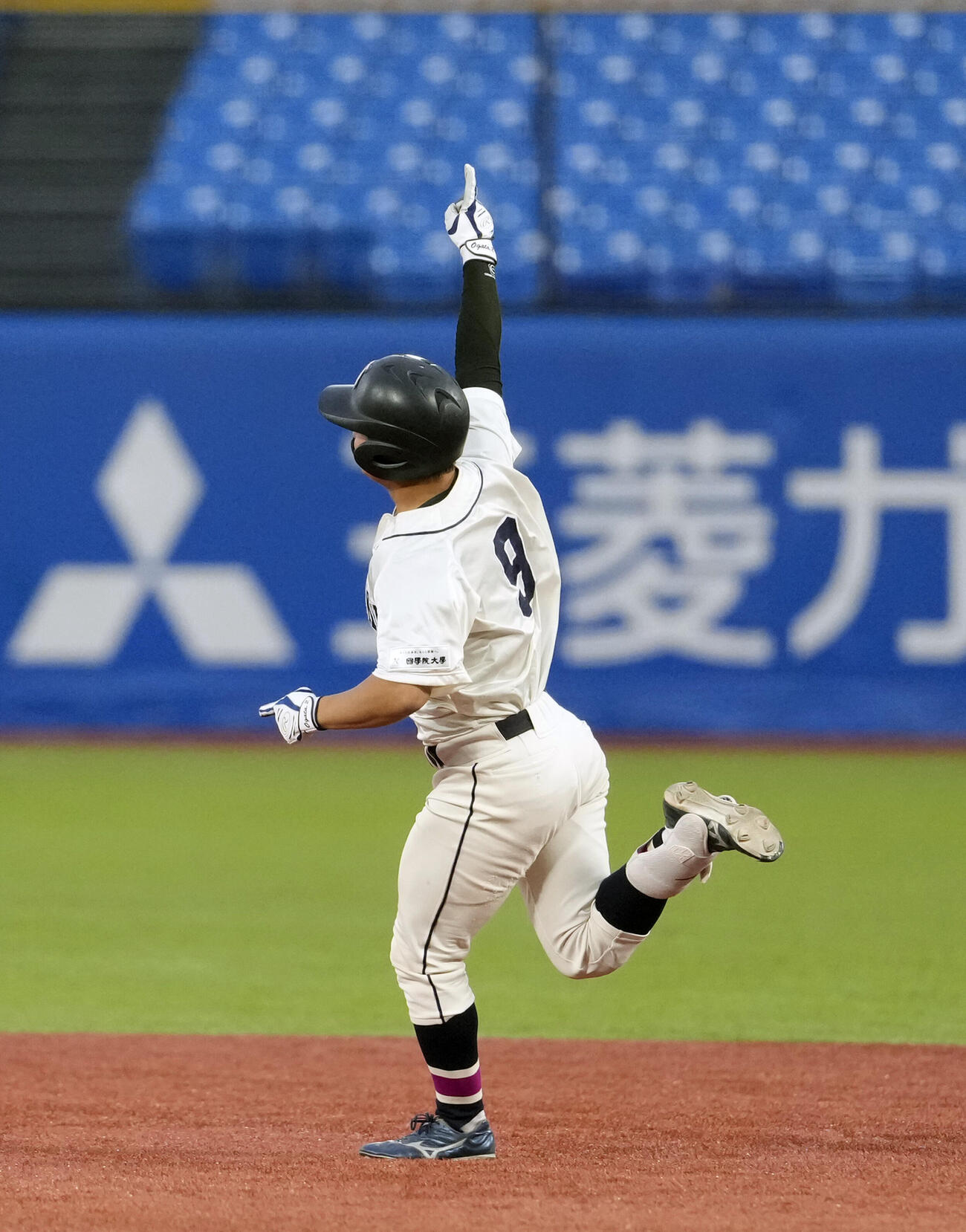 東都大学野球春季リーグ　亜大対国学院大　6回裏国学院大2死、本塁打を放ち、右手を掲げる田井志門（撮影・小島史椰）