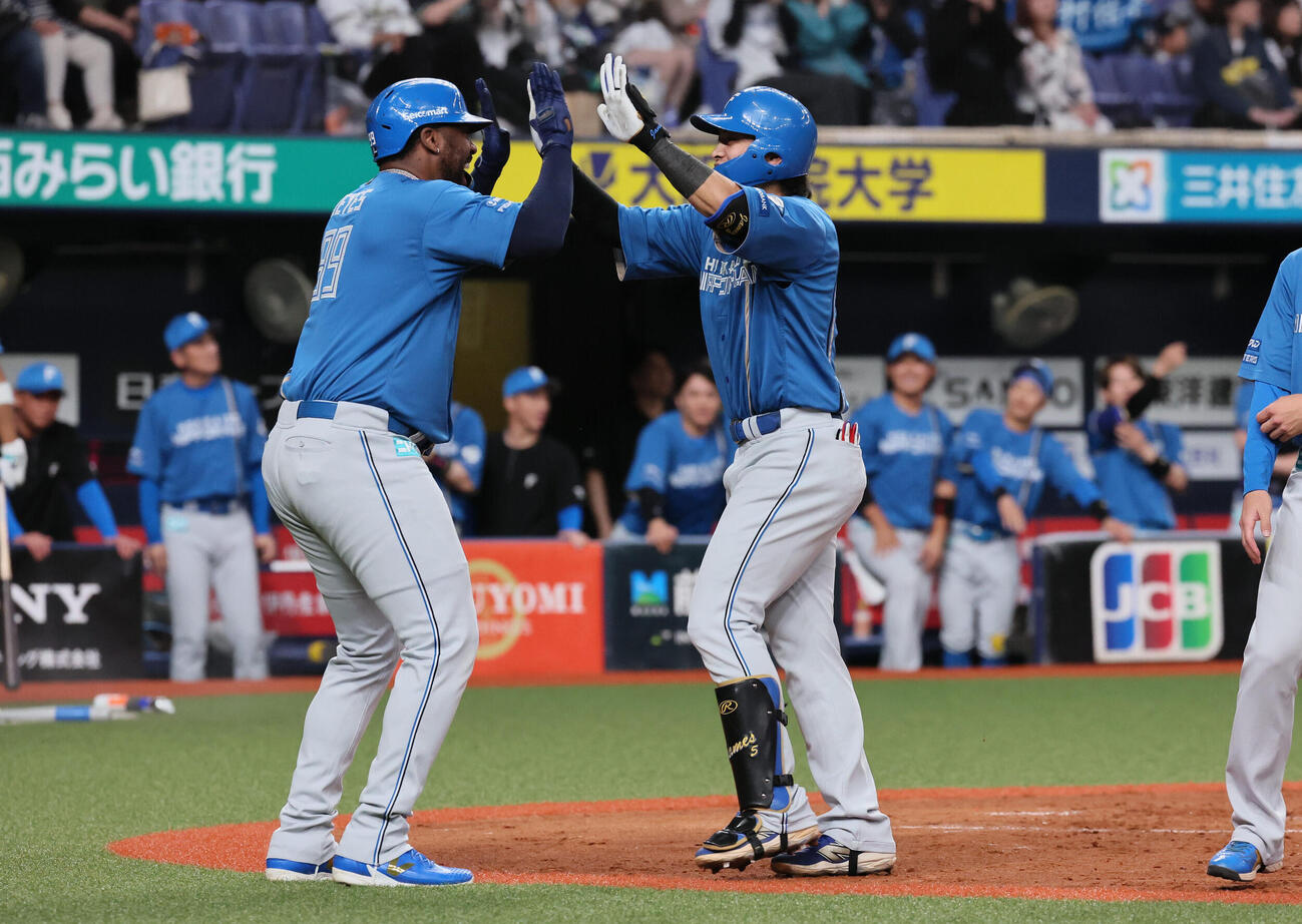 オリックス対日本ハム　5回表日本ハム2死一塁、日本ハム野村佑希は2点本塁打を放ち、フランミル・レイエス（左）に迎えられる（撮影・宮崎幸一）