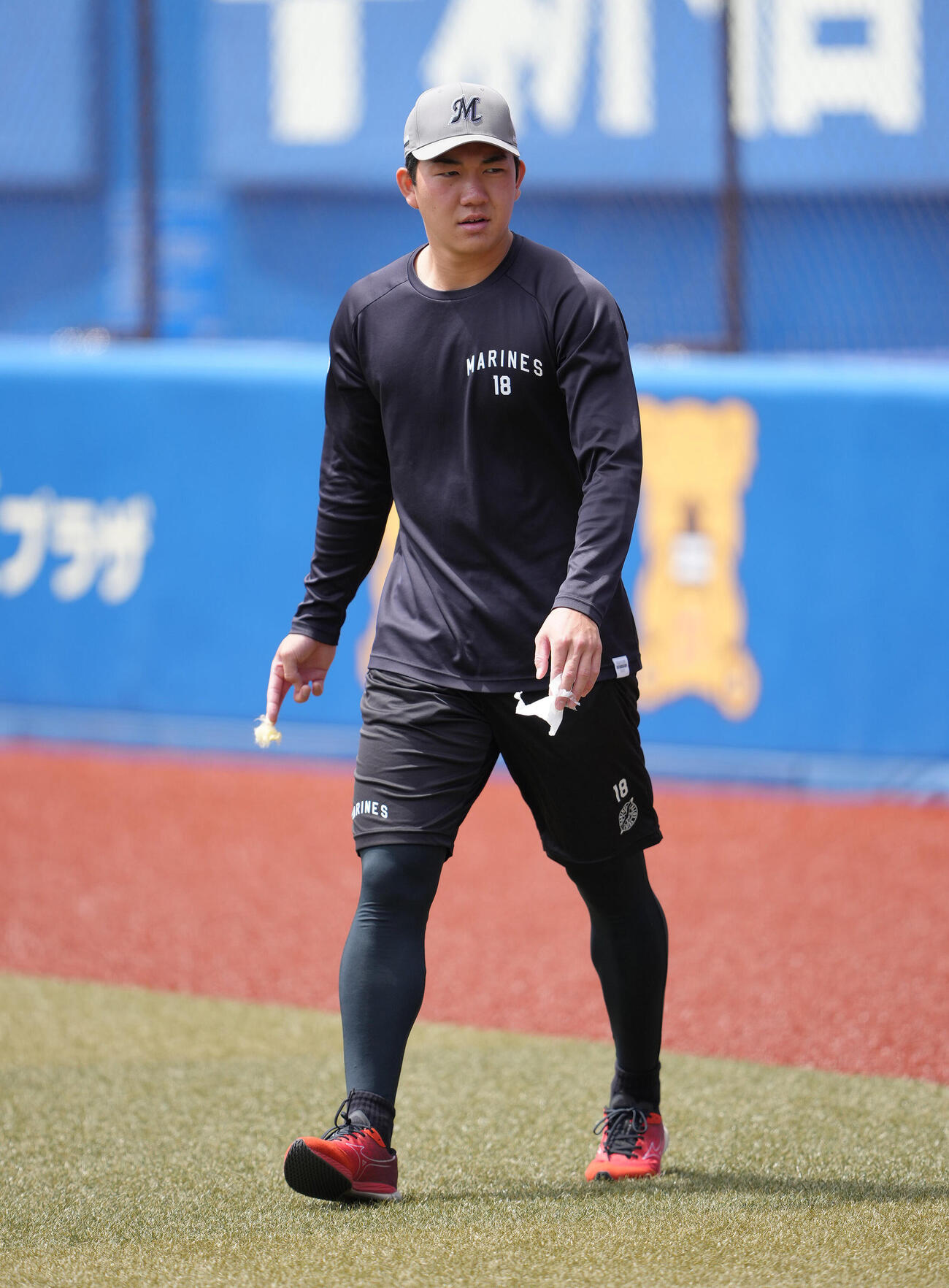 ファーム・リーグ　ロッテ対巨人　試合前、強風でグラウンドに落ちていたゴミを拾うロッテ石垣元気（撮影・足立雅史）