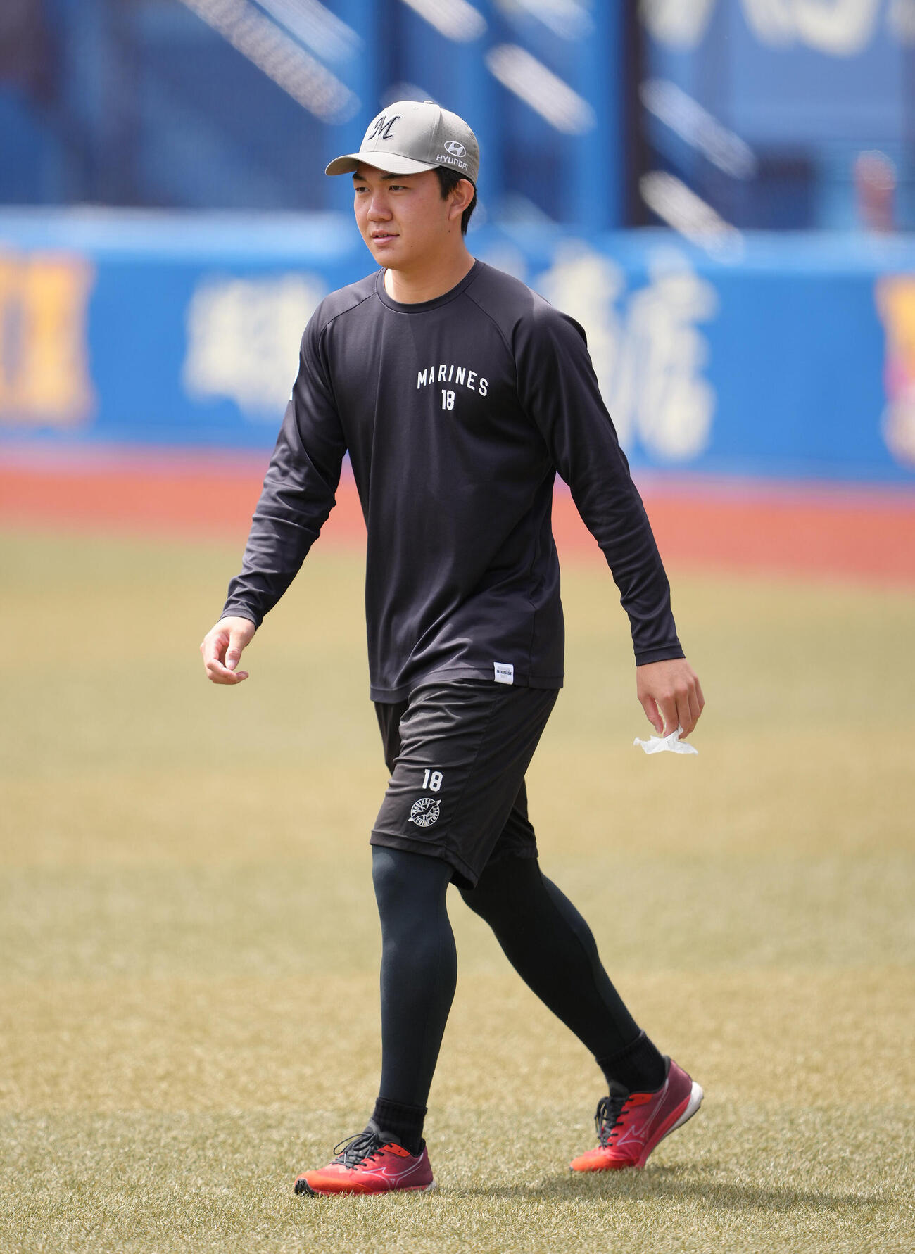 ファーム・リーグ　ロッテ対巨人　試合前、強風でグラウンドに落ちていたゴミを拾うロッテ石垣元気（撮影・足立雅史）