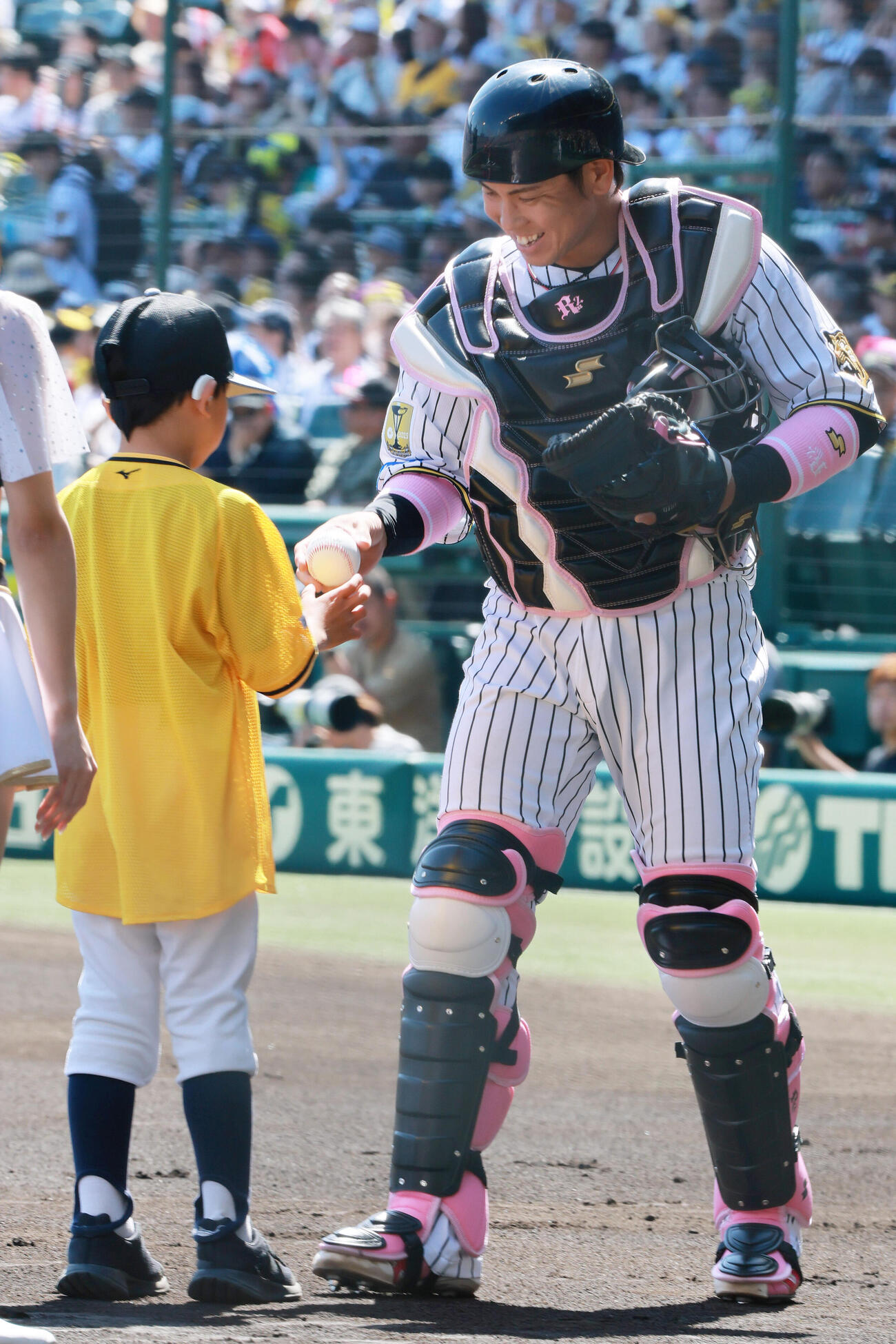阪神対DeNA　試合前、笑顔で児童にボールを渡す阪神梅野隆太郎（撮影・上山淳一）