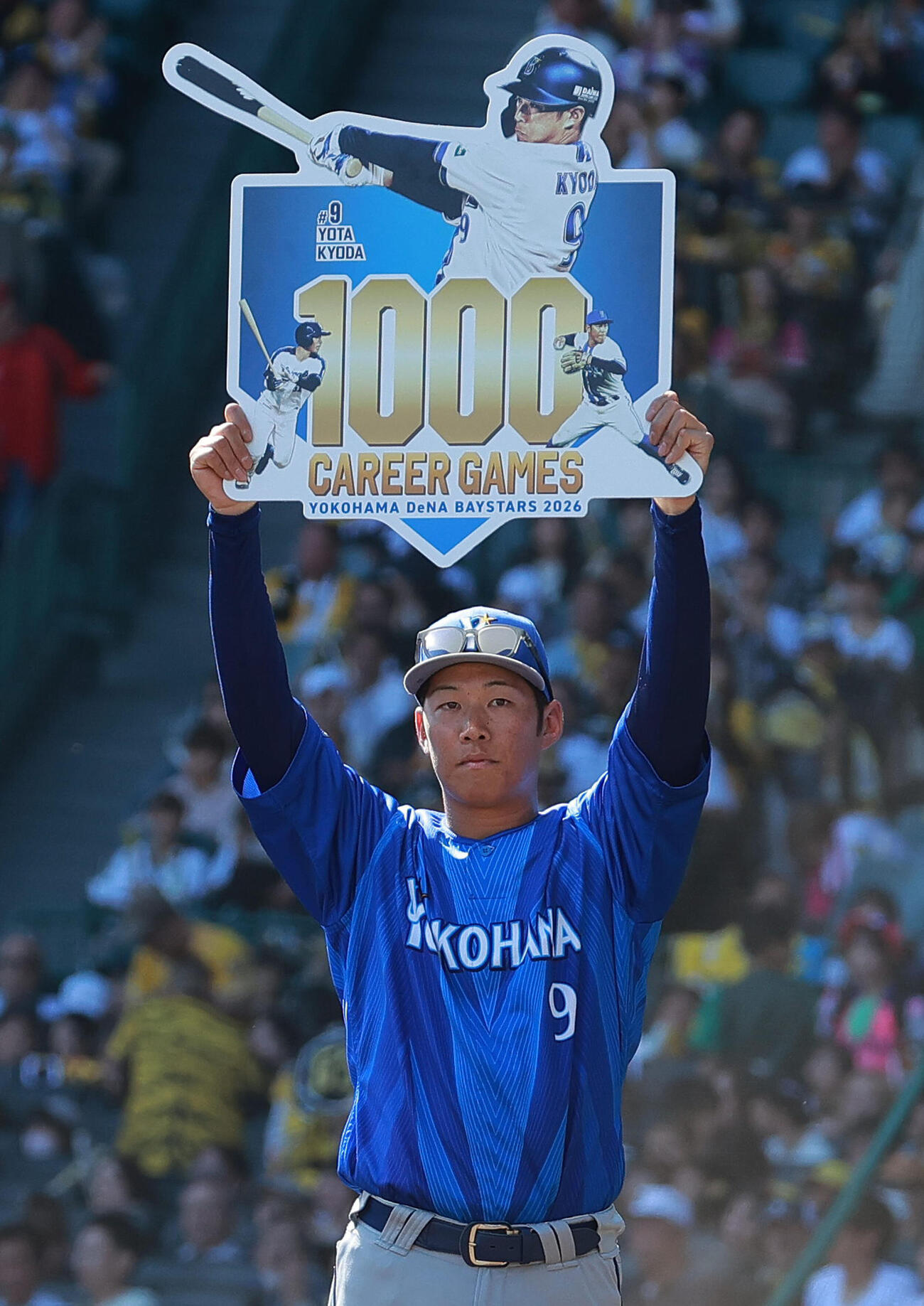 阪神対DeNA DeNA京田陽太はNPB通算1000試合を達成し、記念ボードを掲げる（撮影・上山淳一）