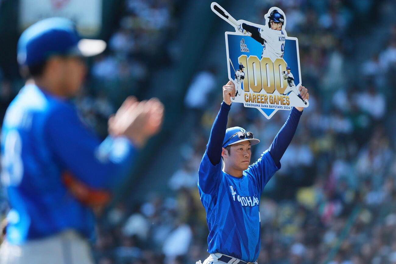 阪神対DeNA DeNA京田陽太はNPB通算1000試合を達成し、記念ボードを掲げる（撮影・上山淳一）