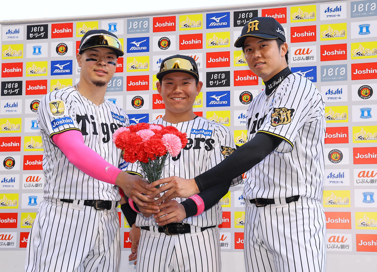 阪神対DeNA　カーネーションを手に笑顔を見せる左から佐藤輝明、嶋村麟士朗、才木浩人（撮影・上田博志）